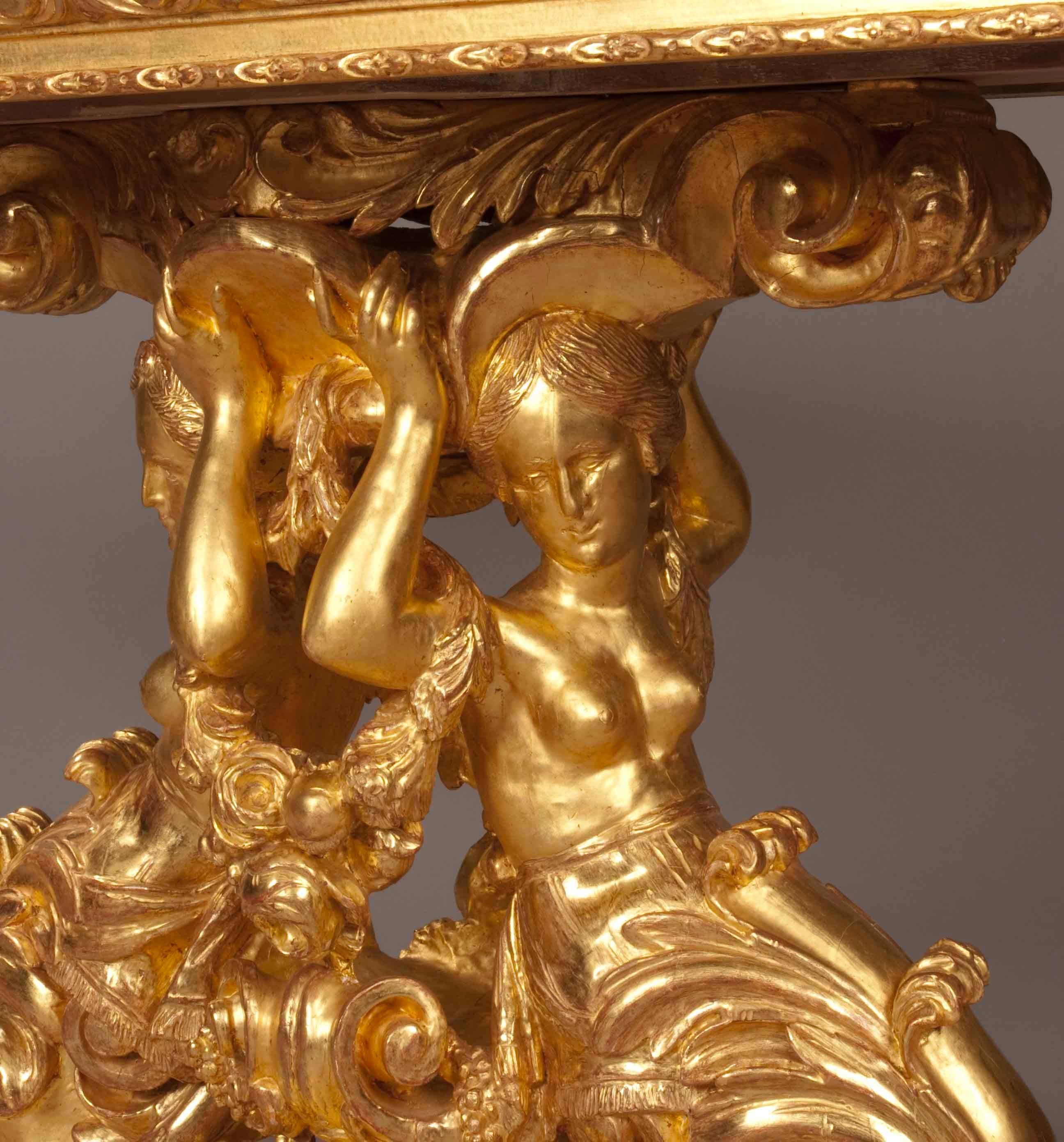 A Fine Centre Table in the Roman Manner

The base in carved wood, gilded and depicting addorsed figures of draped female Manticores, dressed with garlands of flowering roses, supporting the upper frame, which has a running egg and dart moulding,