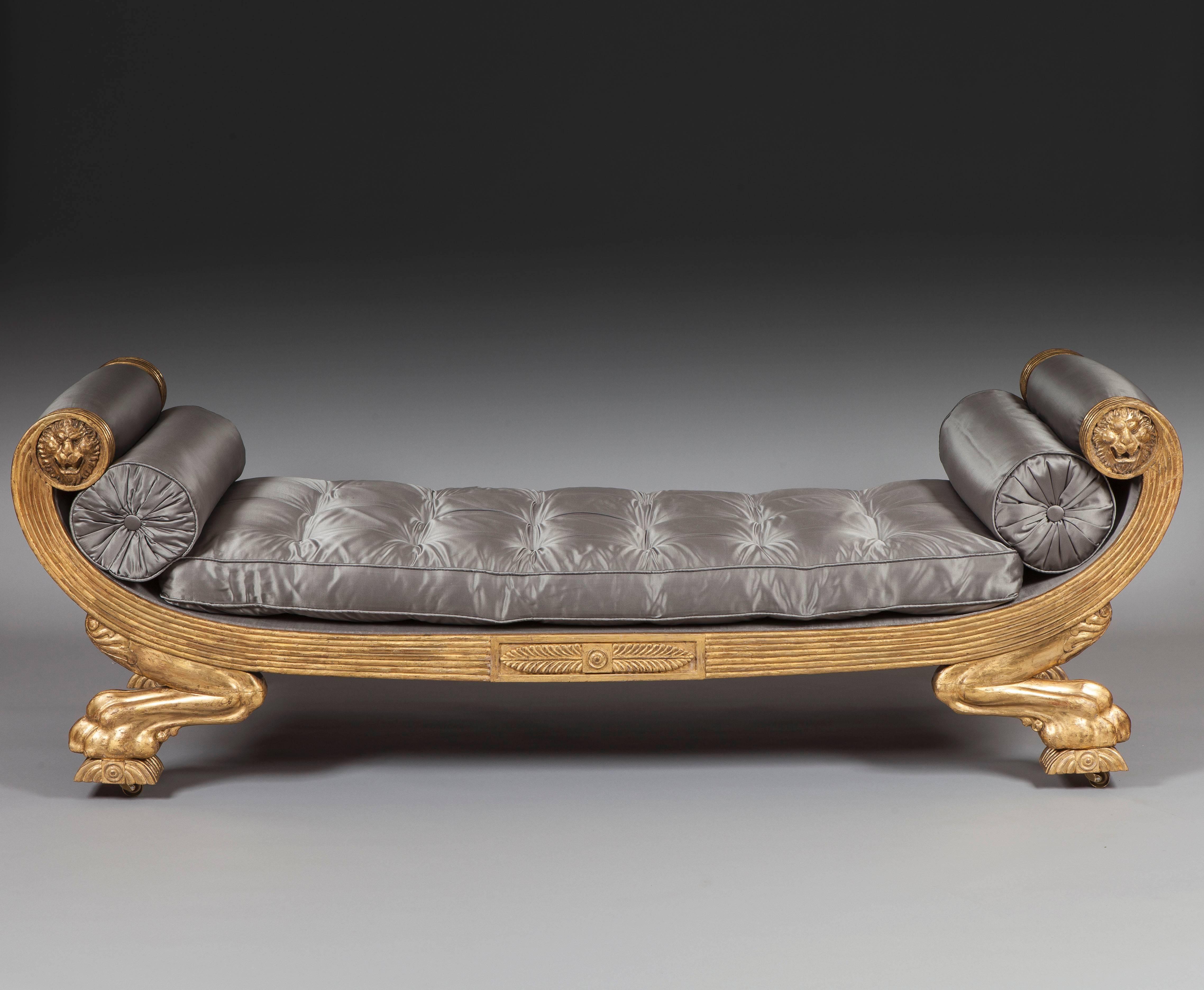 Of freestanding form, constructed in giltwood; rising from caster shod addorsed anthemion decorated legs of leonine design, terminating in paw feet, the channeled frame having rectangular tablets to each side with palmettes, the swept ends being