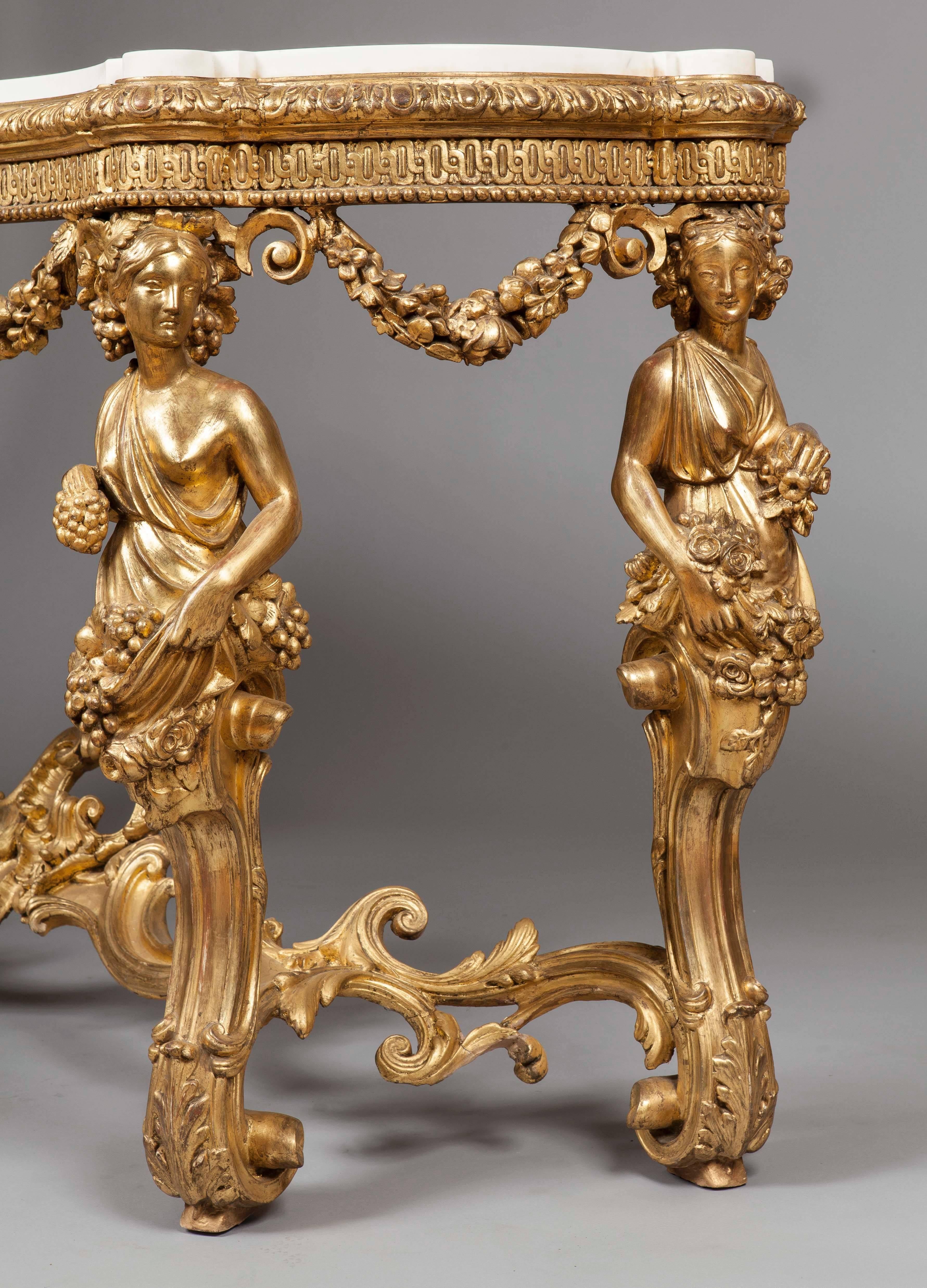 A fine console table in the early Louis XV manner.

Of serpentine form, constructed in giltwood and Carrara marble; four female caryatids bearing flowers issue from scrolled foliate adorned scrolled bases which are conjoined by a swept stretcher