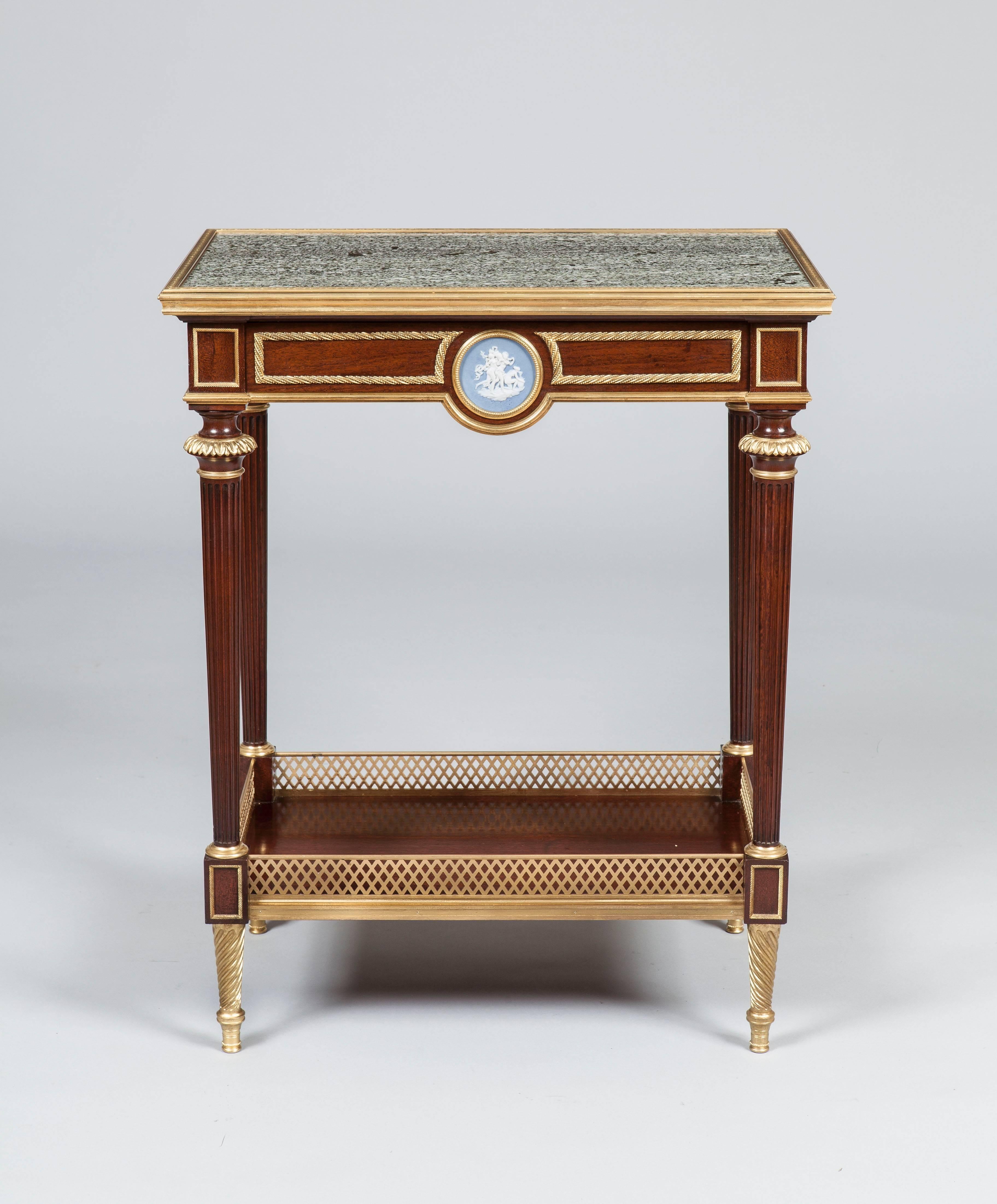 An Occasional Table by Henry Dasson et Cie

Of rectangular form, constructed in mahogany, adorned with bronze mounts, a jasperware plaque in the wedgwood manner, and having an Egyptian sea-green speckled granite platform; rising from tapering