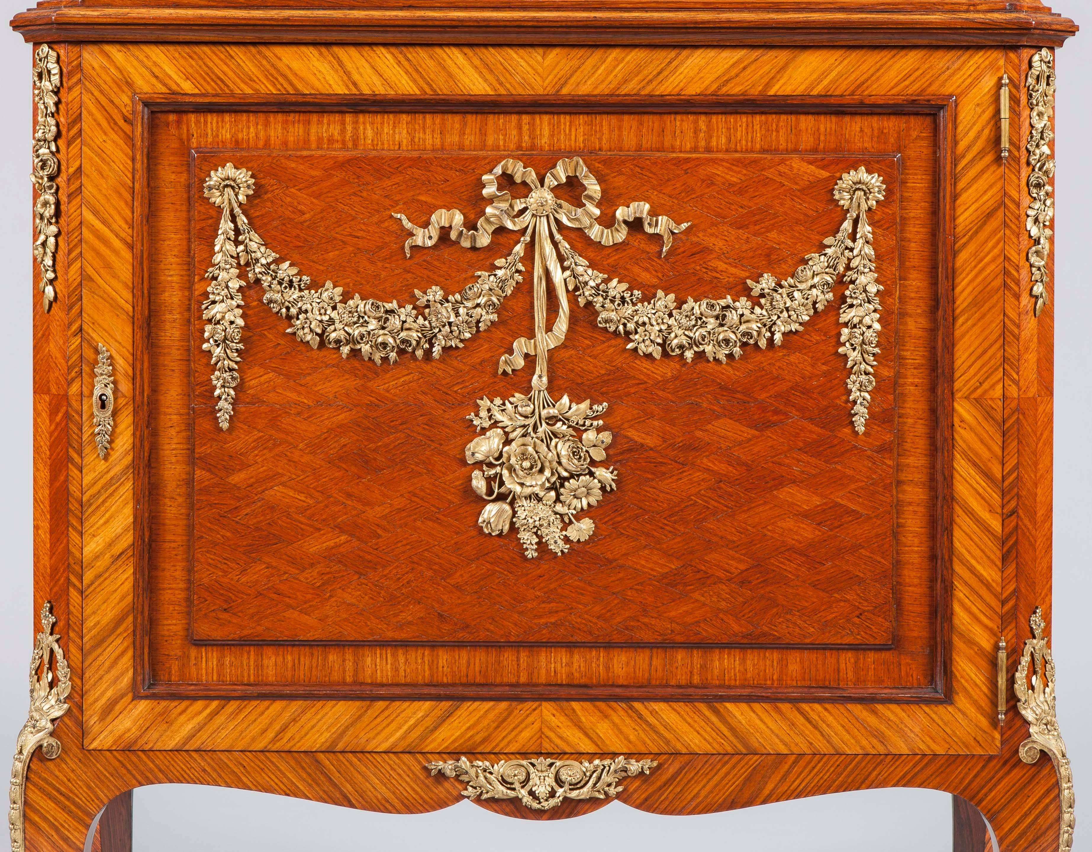 French kingwood parquetry and ormolu-mounted vitrine.

In the Louis XV-XVI Transitional style, of kingwood and tulipwood crossbanding and ormolu mounts. The upper part with a cavetto frieze above a glass shelf enclosed by bevelled glass with a