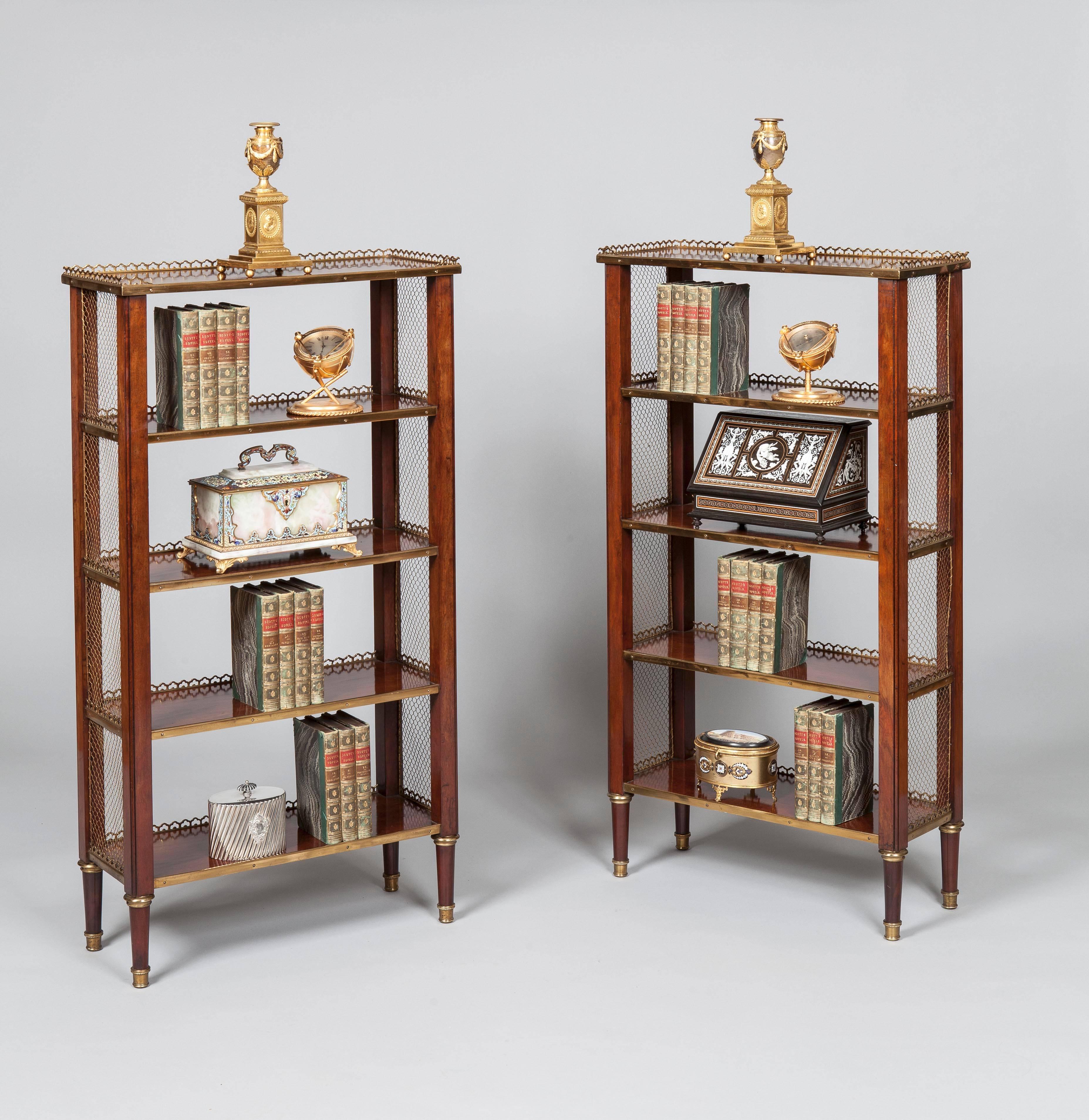 A pair of Petit Bibliotheques in the manner of Adam Weisweiler

constructed using a finely patinated mahogany, brass and bronze; rising from bronze shod turned and tapering circular legs supporting shaped square section reeded angles, each of which