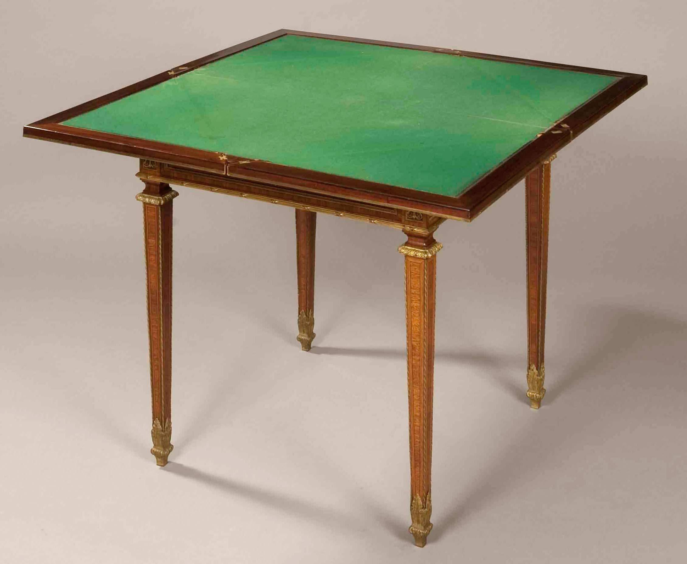 A fine card table in the Louis XVI manner.

Constructed in kingwood with purpleheart crossbanding, and dressed with superbly cast and chased mercury gilt bronze mounts; rising from tapering legs, with bronze sabots cast as leaves and atop, an