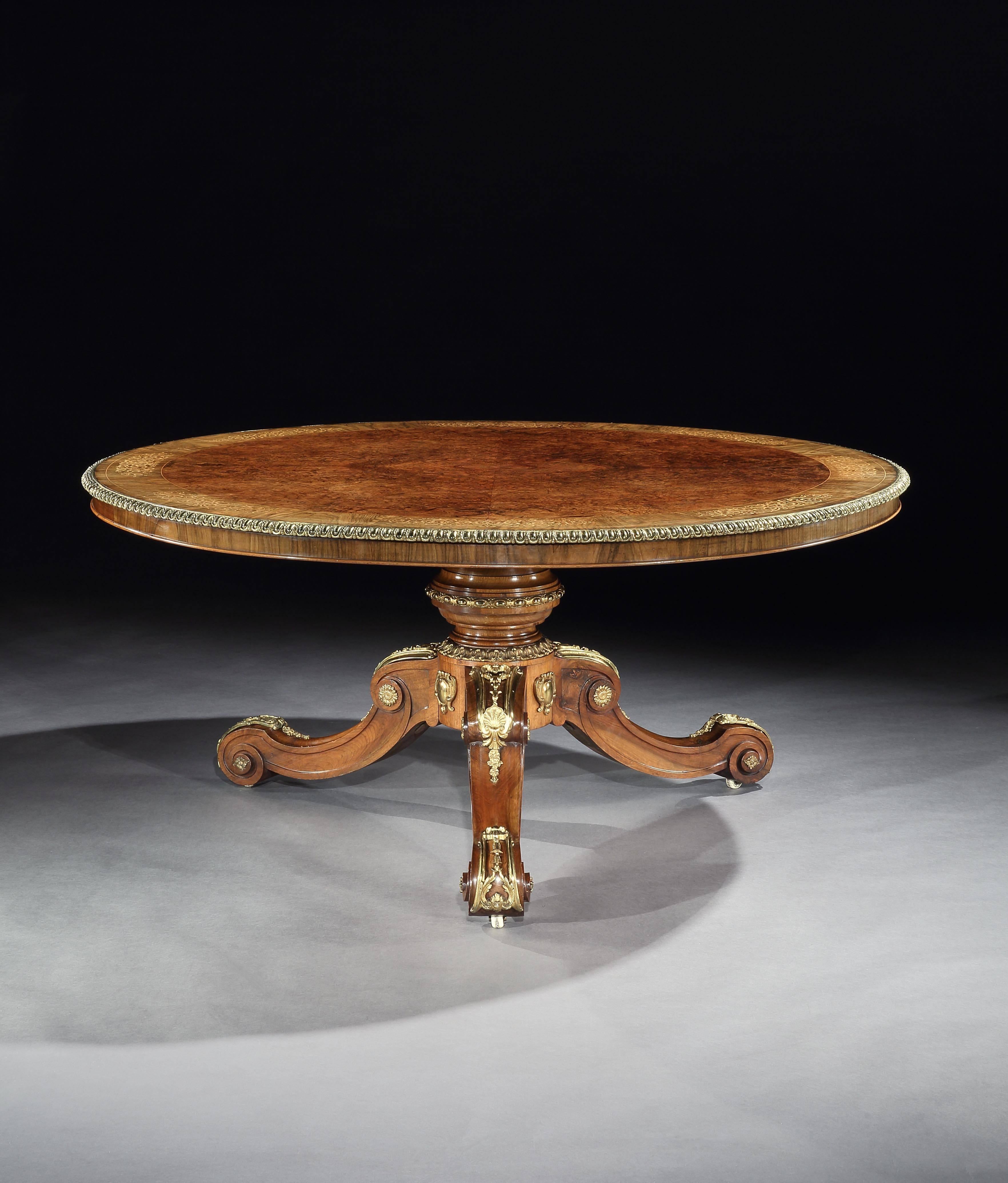 A large marquetry centre table in the manner of Holland and Sons

Constructed in finely marked European & Circassian walnut, with extensive ormolu enhancements and foliate inlays in boxwood; rising from a tripartite swept leg base, the scrolled