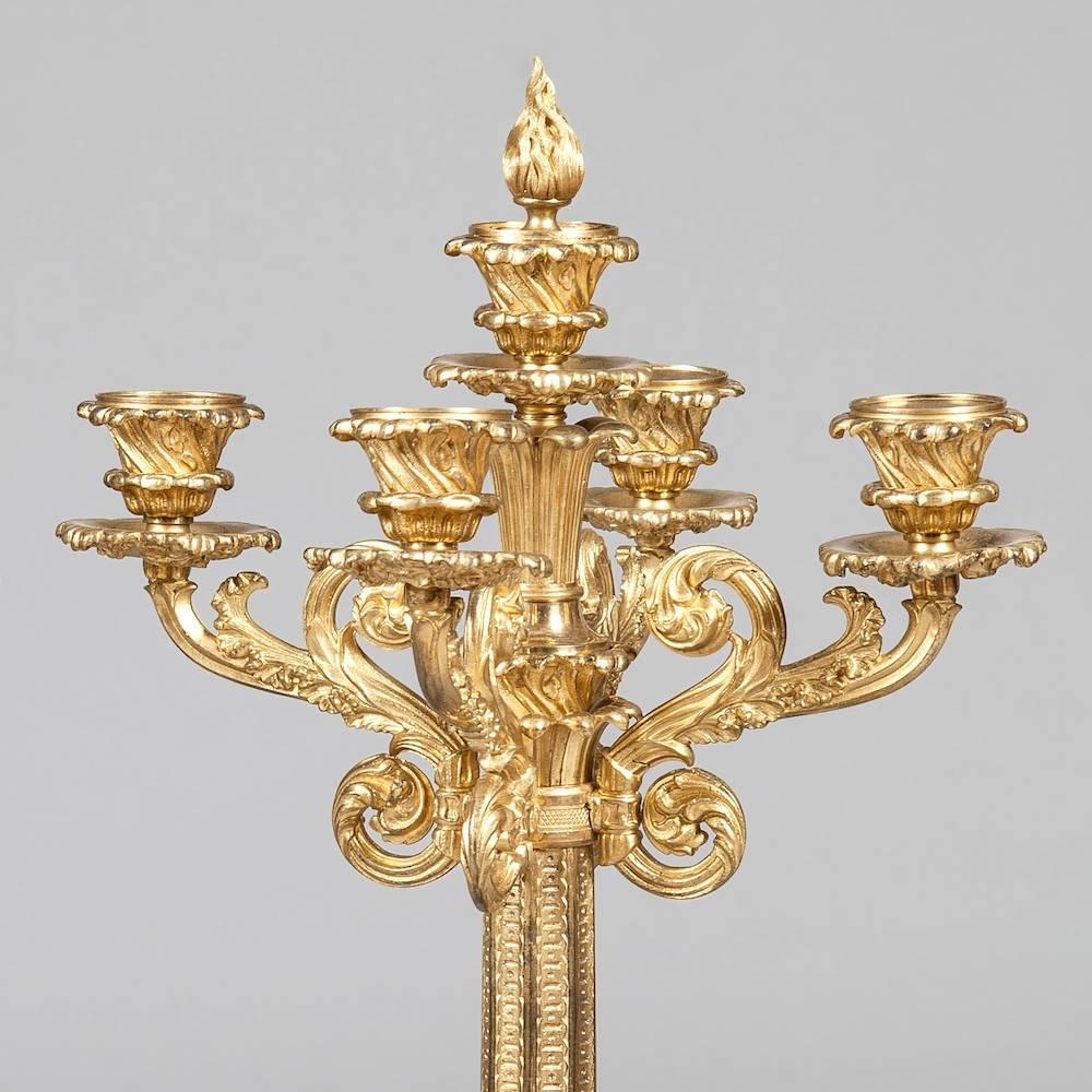 A good pair of candelabra of the William IV period

Constructed in gold leaf gilt bronze; rising from square bases, with scrolled plinths supporting octagonal sided imbricated cast columns, each having four ‘S’ scrolled and decorated candle arms and