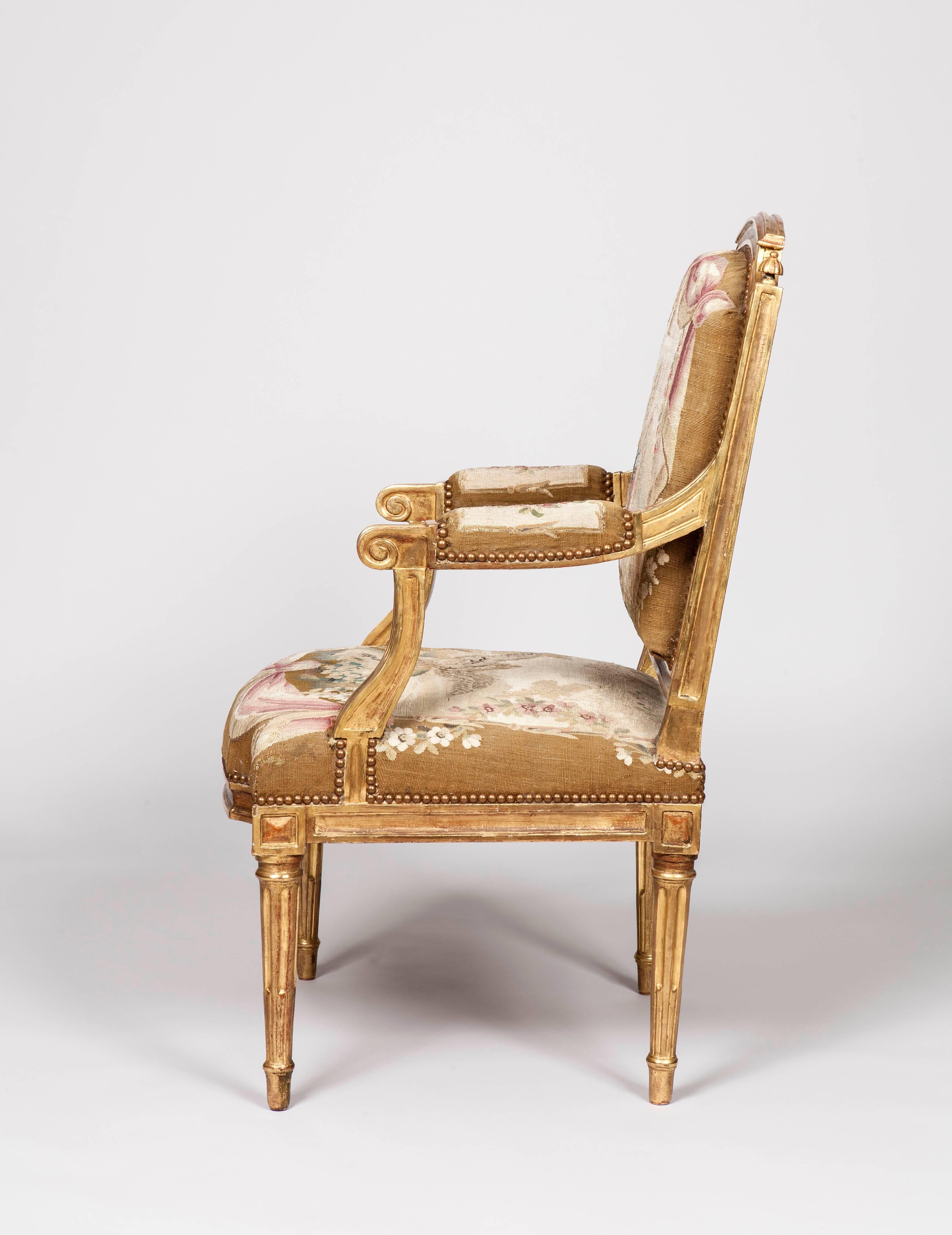 A good pair of Louis XVI Period Fauteuils a la Reine
in the Manner of Pierre Bernard.

Constructed in giltwood, with the backs and seats covered with Beauvais tapestry panels; rising from ring turned and tapering fluted legs, having shaped side