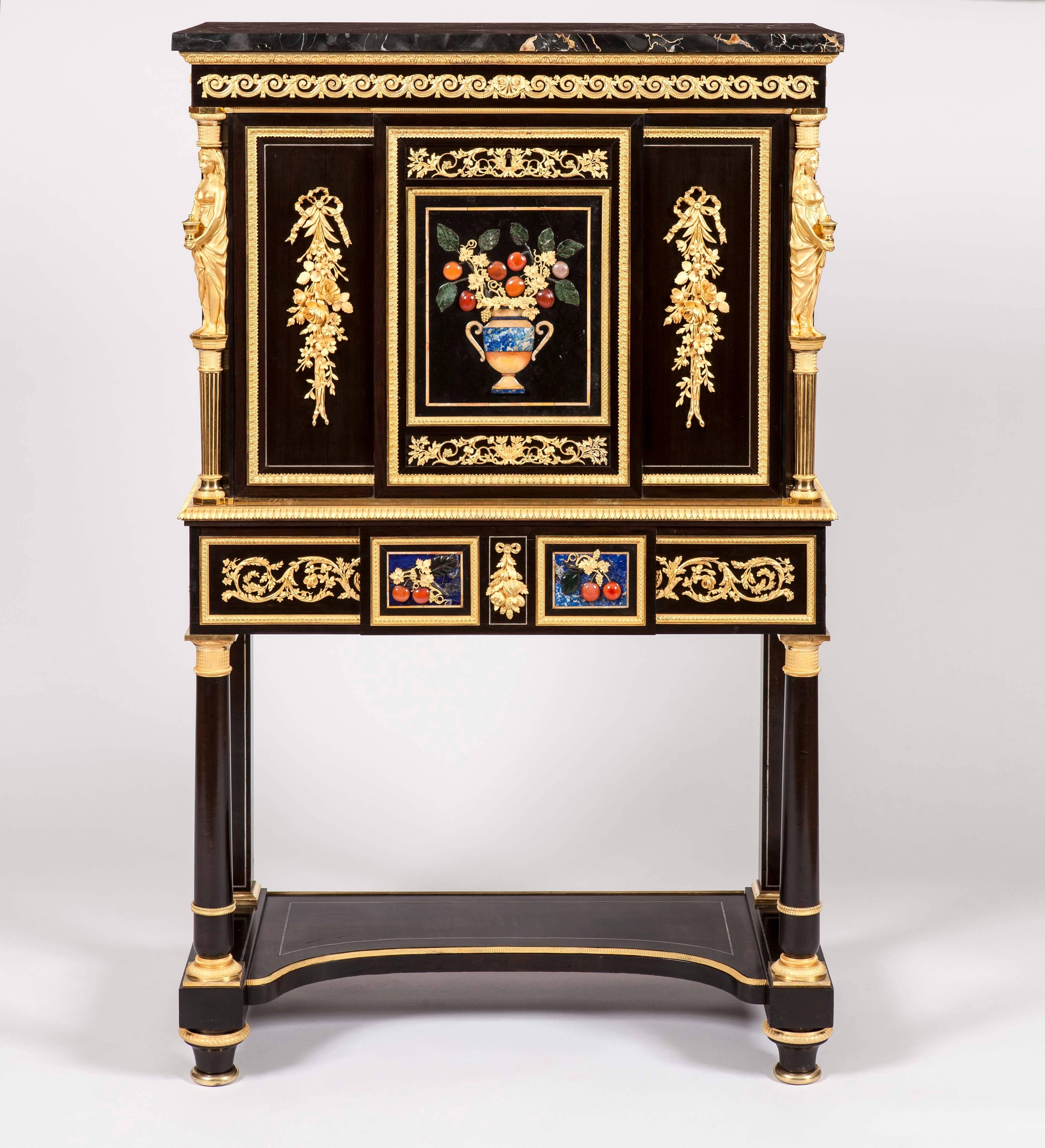 A fine pair of secrétaires à Abattant
Attributed to Alexandre-Louis Bellangé

Constructed in ebony, and dressed with two-color gold ormolu mounts, made with exceptional refinement, Florentine Pietra Dura panels (with colors of blue, red, orange and