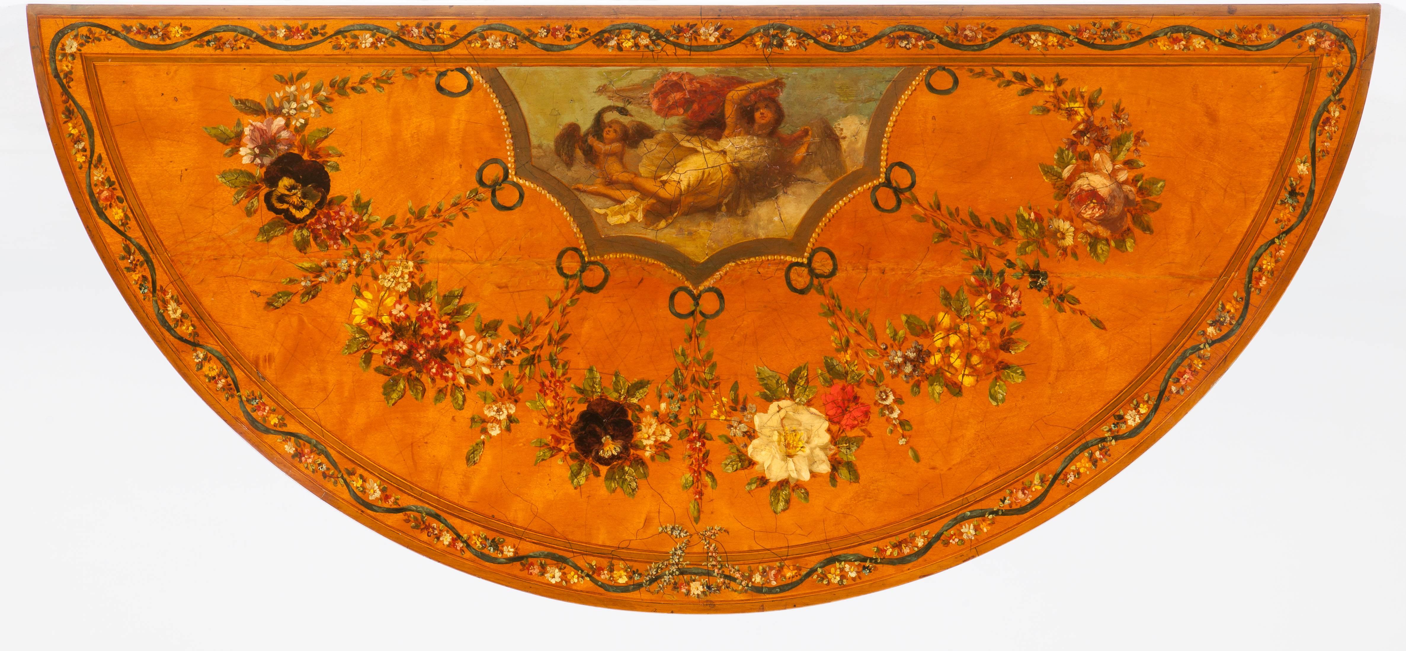 A pair of demilune commodes in the Adam Manner

Constructed in a finely figured satinwood, which has been hand decorated in polychromes (of red, white, green) and highlighted in gold leaf gilt work; rising from turned, tapering feet, each with a