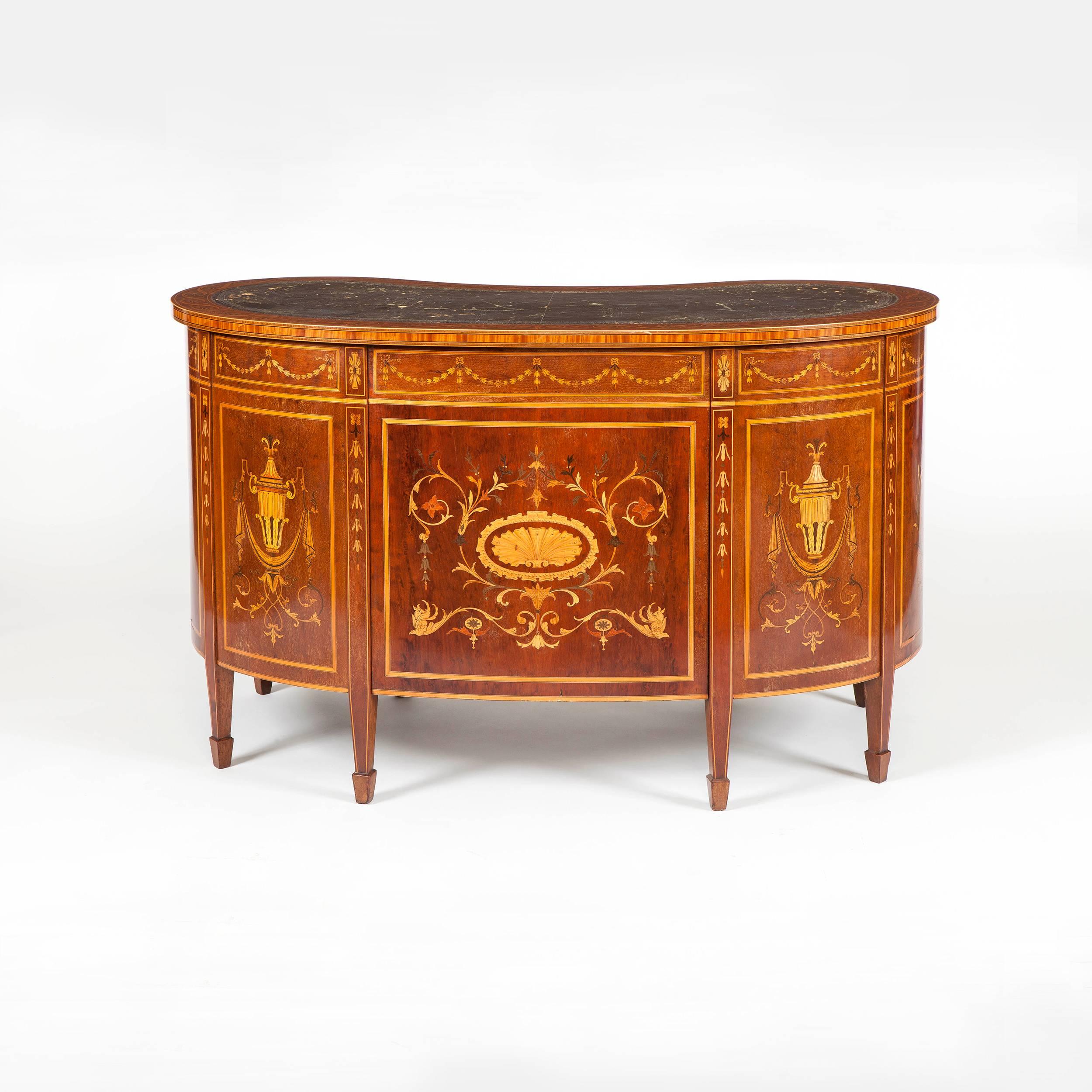 A kneehole library desk attributed to Edwards & Roberts.
Retailed by Druce & Co

Of kidney form constructed in a well patinated mahogany, extensively inlaid with specimen woods; rising from tapered spade end feet, of nine drawer form, all oak