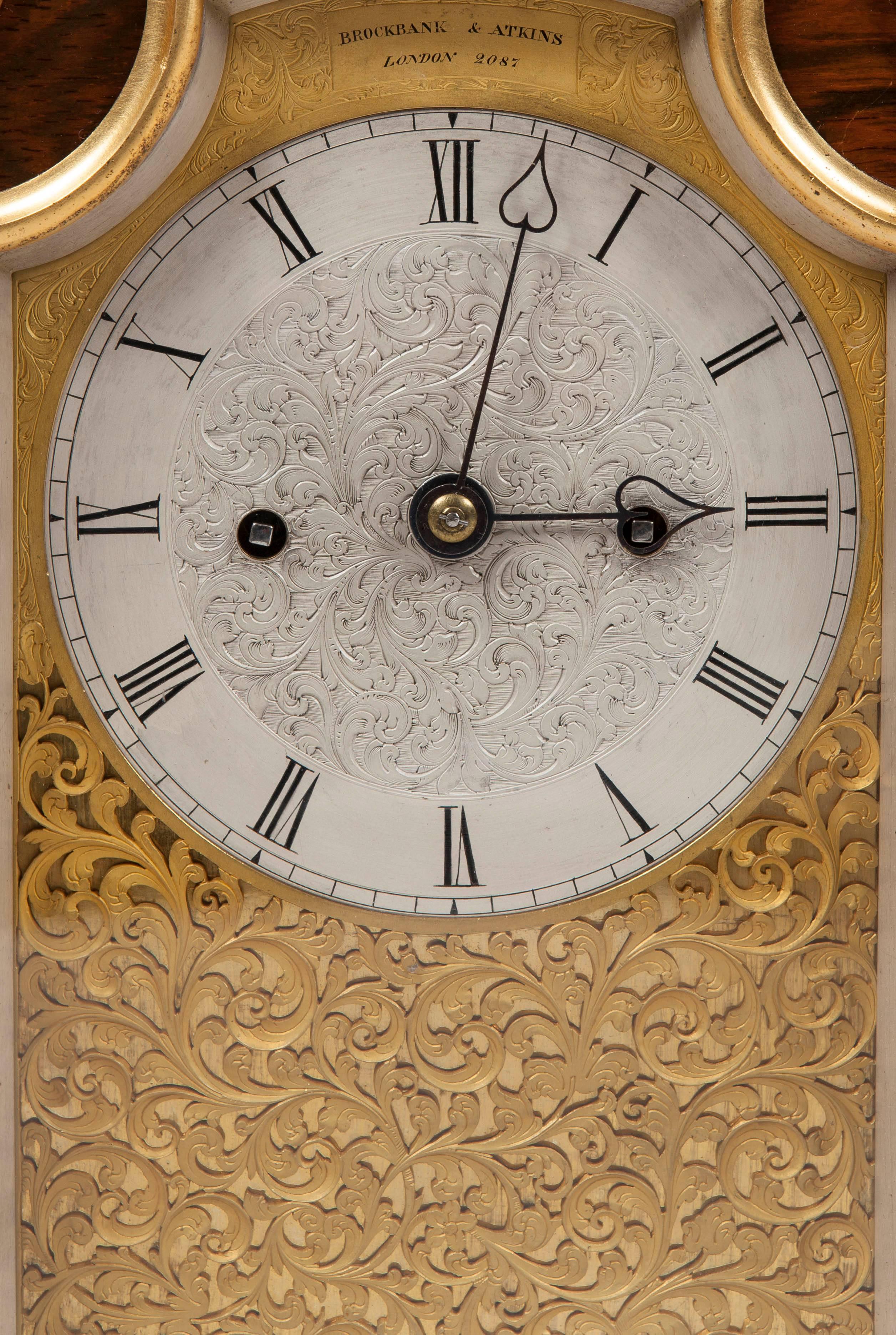 A table clock by Brockbank and Atkins of London

The finely marked goncalo alves case adorned with ormolu mounts, having foliate scroll feet, the top arched, and dressed with further ormolu scrolls and columns to the fascia, with glass side