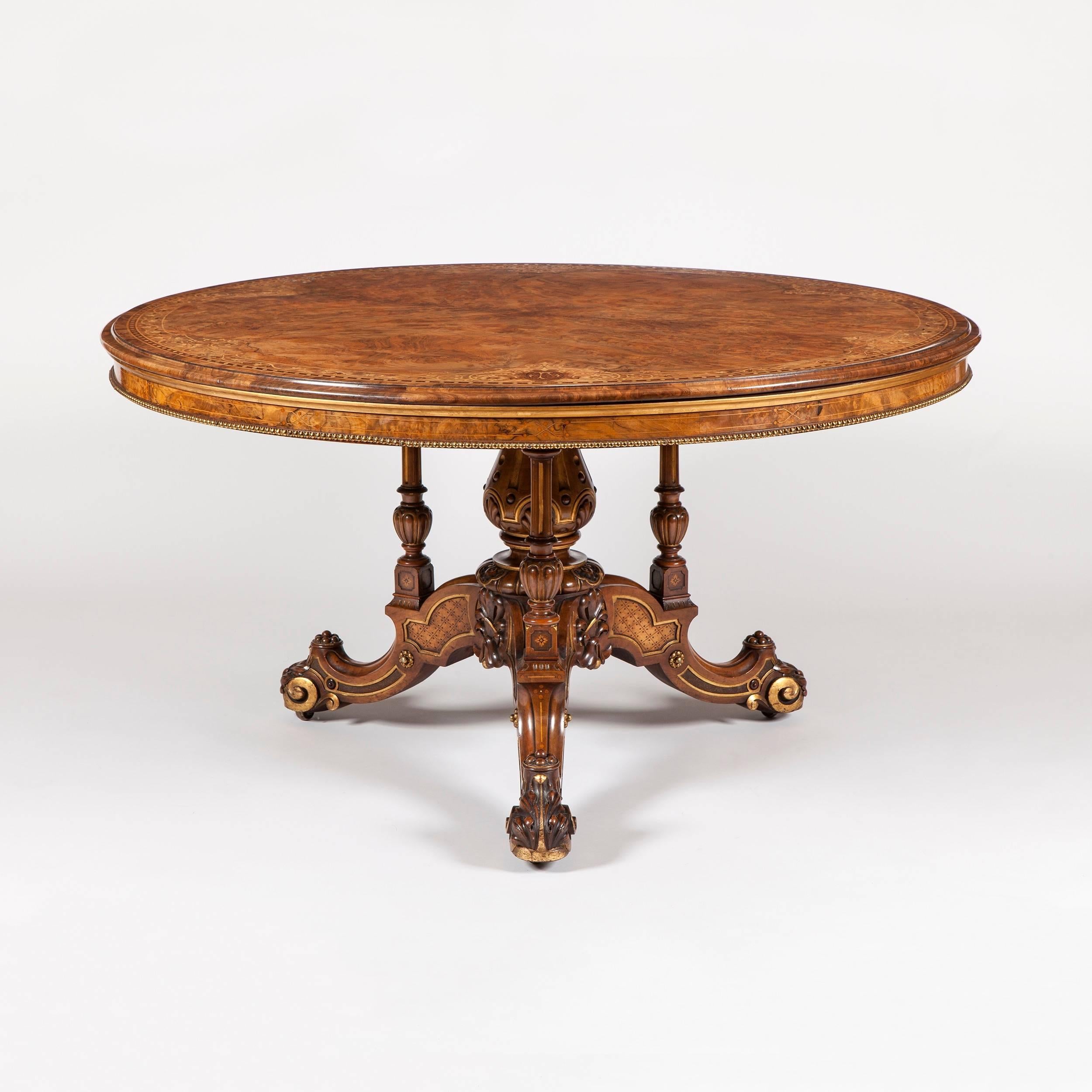 Table centrale du milieu du 19e siècle par Johnstone & Jeanes de Londres.

Construite en noyer, avec des incrustations de marqueterie détaillées et des rehauts de laiton et de dorure, elle s'élève sur une base tripartite à pieds cabriole, munie de