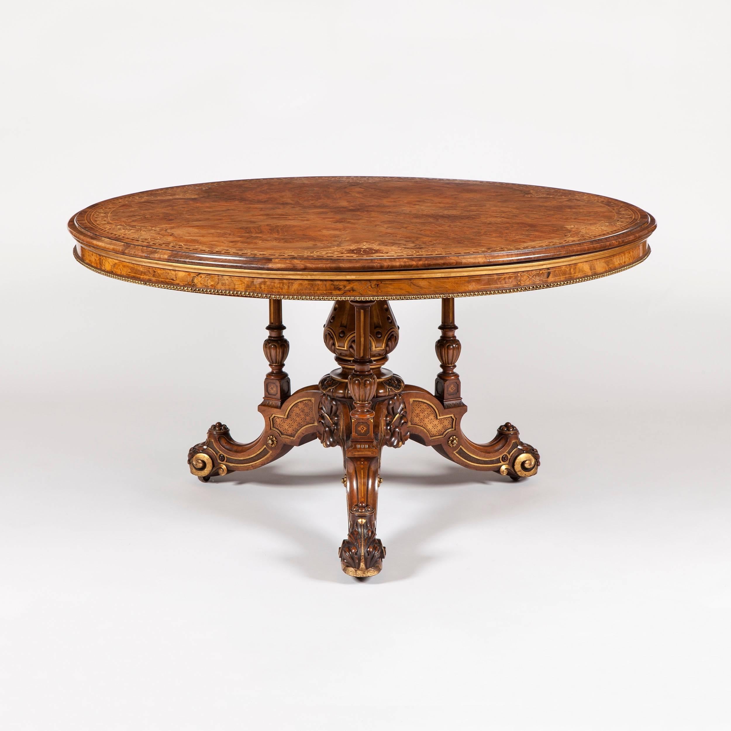 A mid-19th century center table by Johnstone & Jeanes of London.

Constructed in walnut, with detailed marquetry inlay work and brass and gilt highlights; rising from a castor shod tripartite knurled and scrolled cabriole legged base issuing