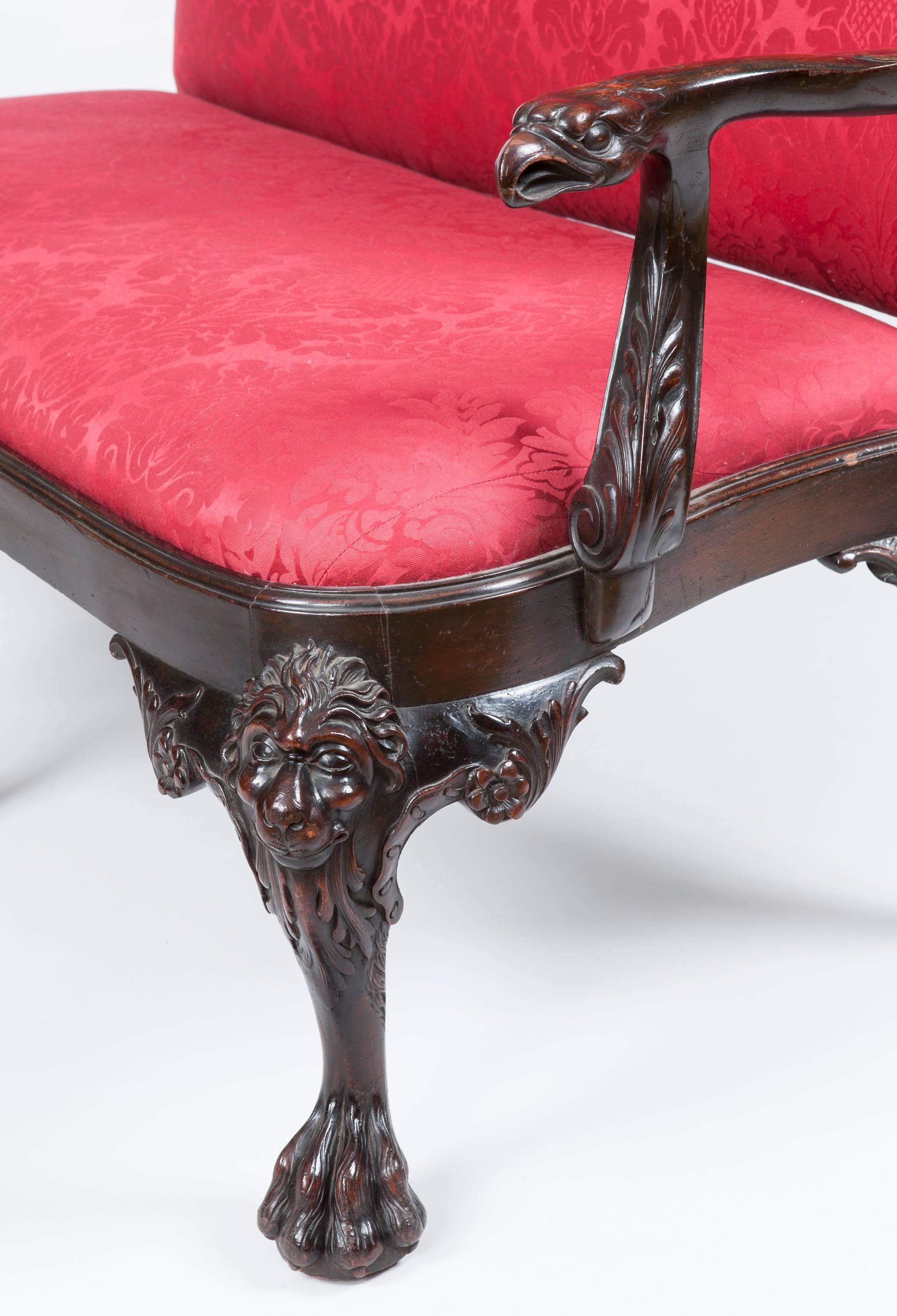 A Settee in the Early Georgian Manner

Constructed in red walnut, and reupholstered recently in a patterned damask; rising from cabriole legs with 'hairy paw' feet, with lion masks atop: the serpentine front and side rails carved with acanthus