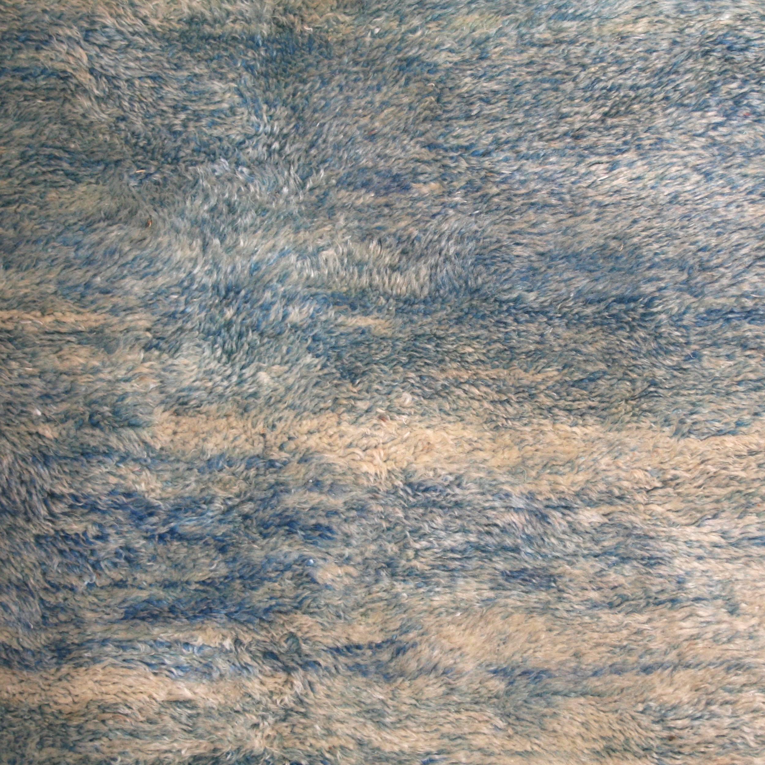 A large Berber carpet from the Middle Atlas woven in many gradations of blue in its lightest shades. Woven with the best quality wool available in Morocco in a higher knot density than usual and with a lower shear for a wool, imparting a unique