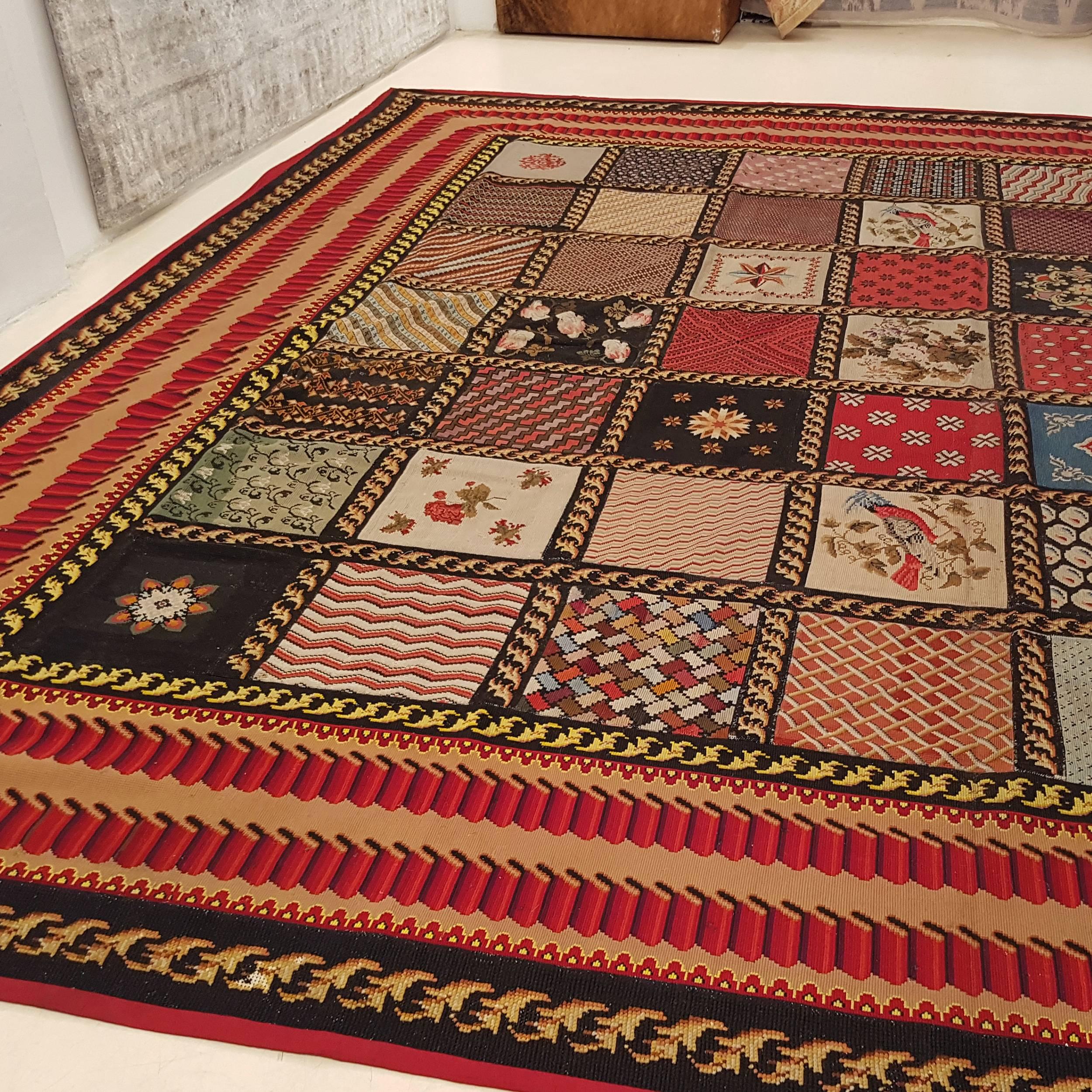 A large antique English needlepoint carpet decorated by the so-called 'album' pattern, composed of square compartments each containing a different pattern. This was the traditional way of weaving needlepoints, as the various embroiderers would each