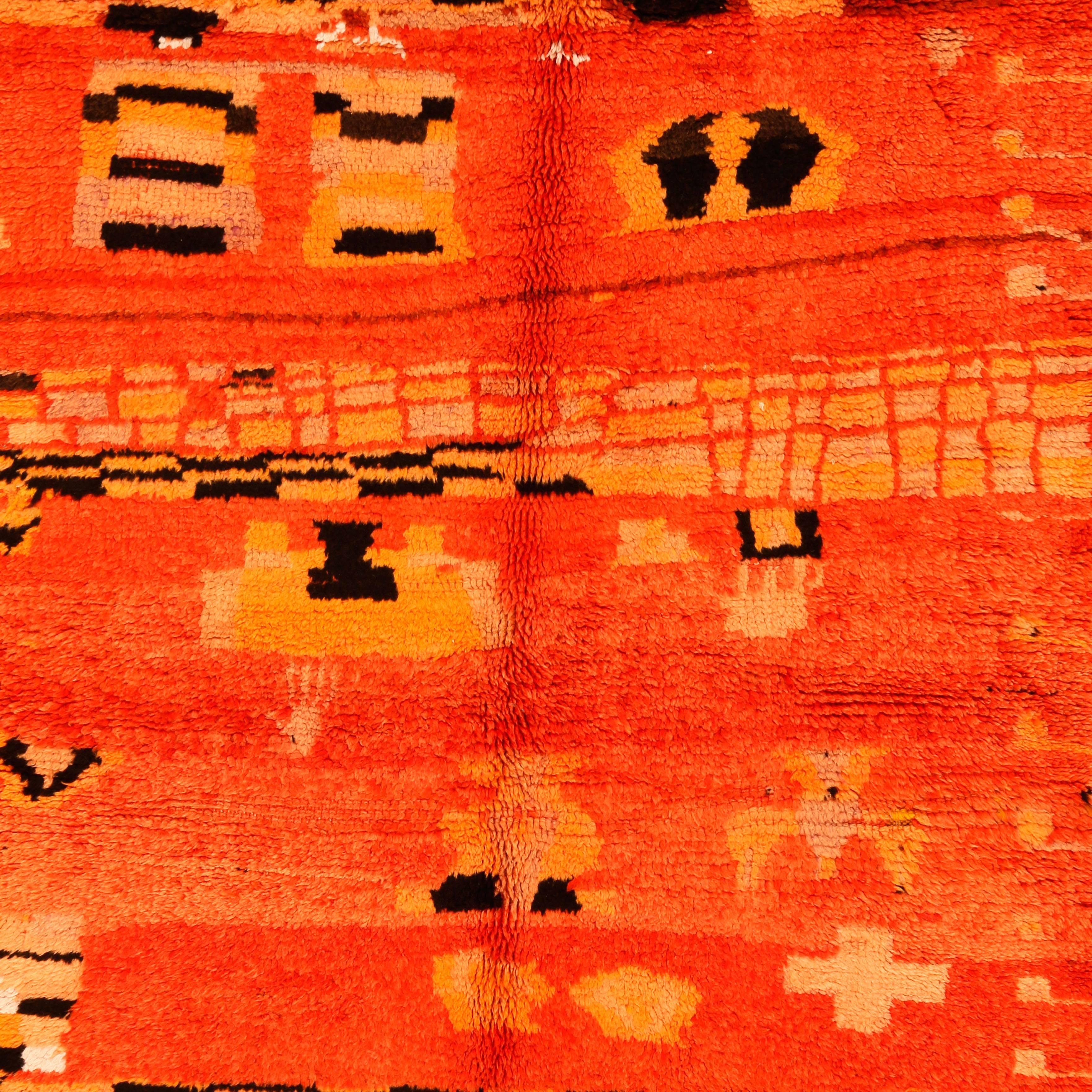The Berber weavings from the Rehamna region, located in the plains near Marrakesh, are typically decorated by abstract geometric motifs on a red-orange ground. This example is embellished by various attempts at creating a chequerboard pattern