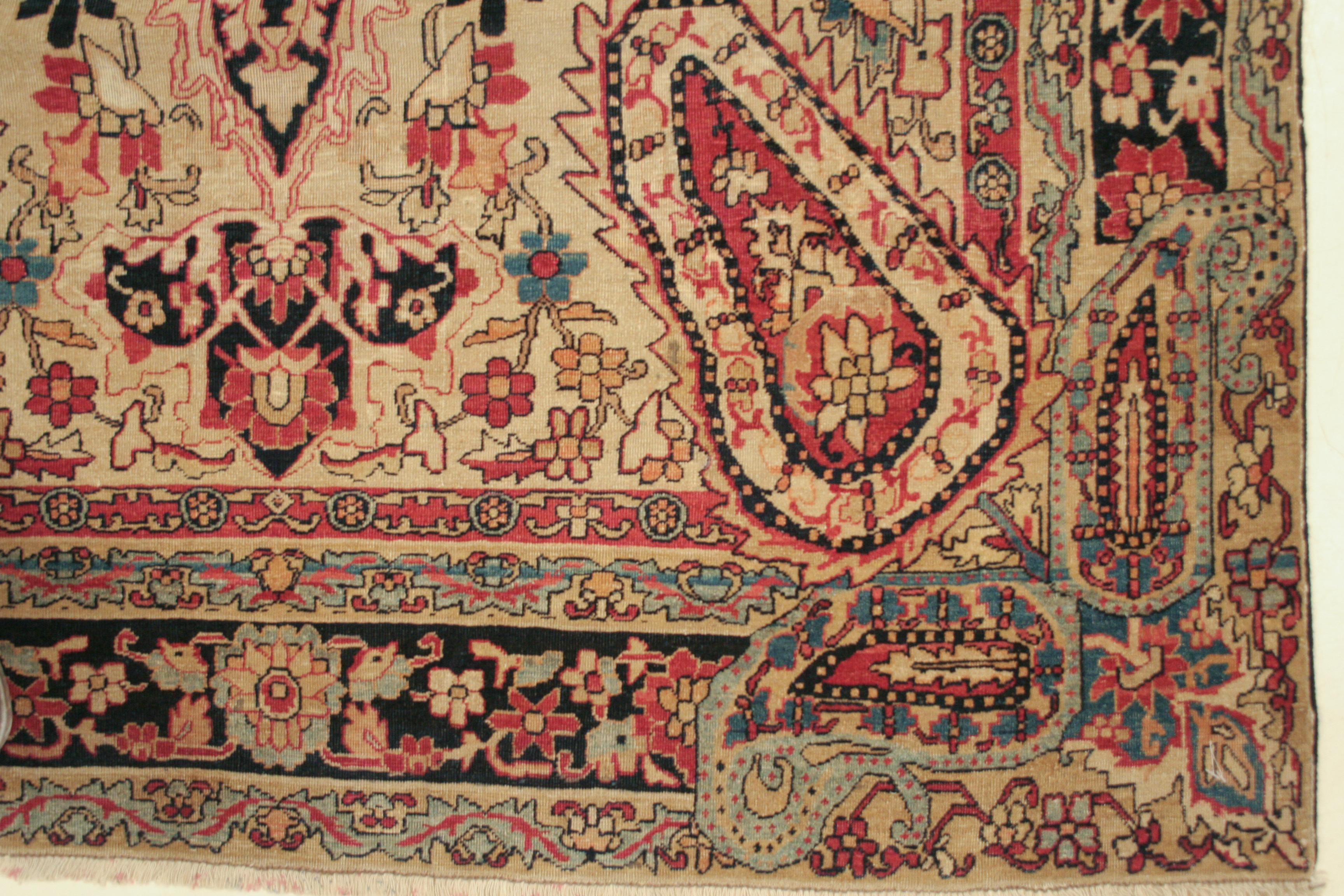 Un tapis Lavar Byman d'une grande finesse et d'un millésime précoce, dont le fond crème est orné d'une profusion de vrilles feuillues et de palmettes disposées autour d'un médaillon central délicatement dessiné. Cette composition est flanquée de