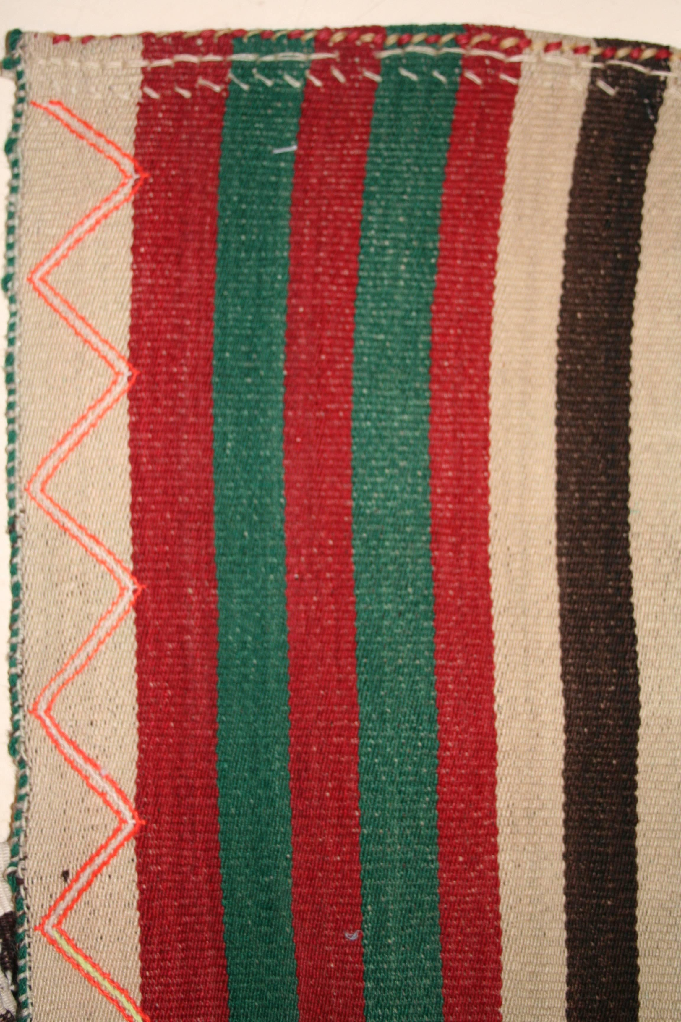 A colorful Qashqa'i flat-weave composed of multicolored vertical bands on an ivory background. It consists of two panels woven separately and then joined together at the centre. These are woven in the weft-substitution technique also known as Jajim.