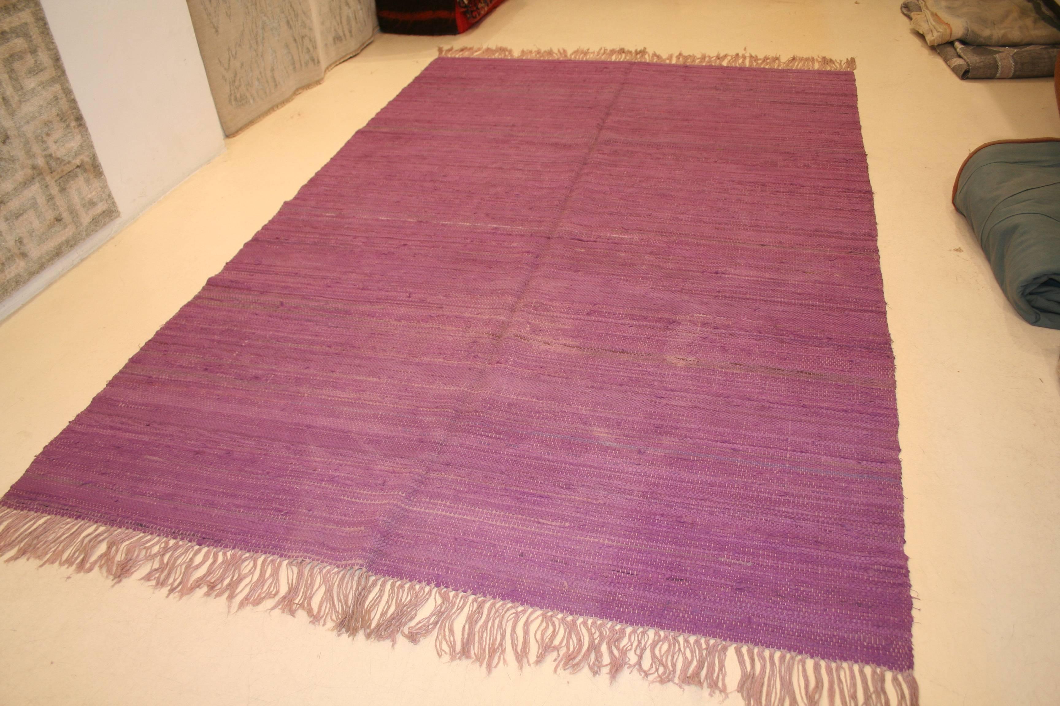 A decorative and unusual Moroccan Berber kilim from the Middle Atlas distinguished by a purple open field.