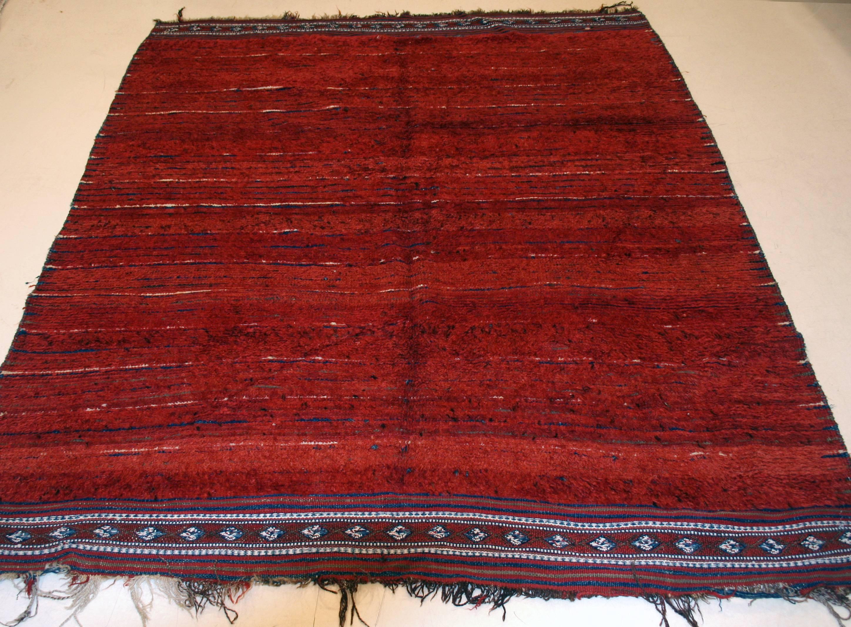 A very rare and unusual Uzbek rug from Central Asia distinguished by a warm and rich red open field background, a natural color extracted from the madder plant. This background is embellished by the striped computed wefts, the colors of which