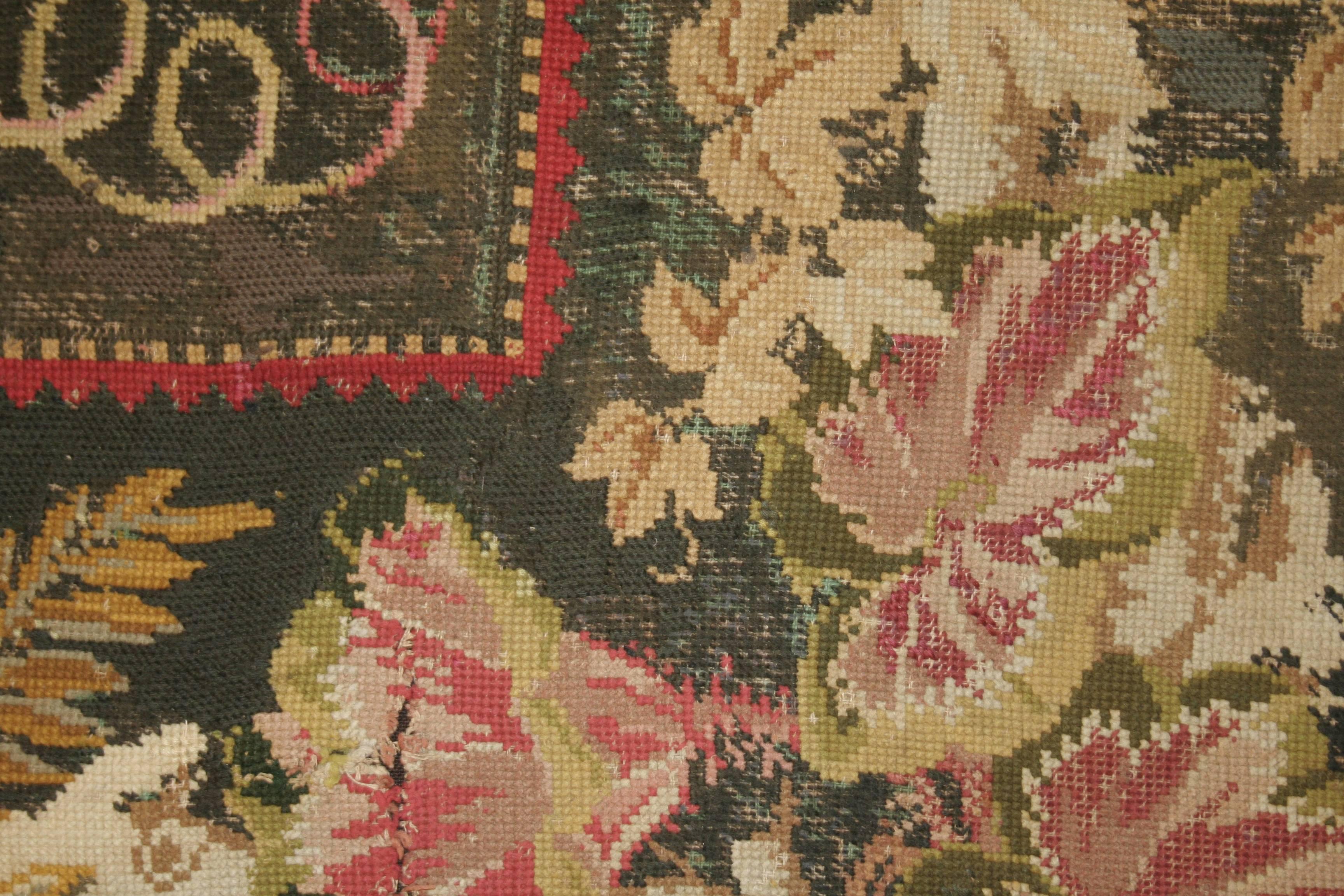 Una encantadora alfombra de punto de aguja caracterizada por un ramo central bien articulado y arremolinado sobre un fondo verde oliva oscuro. Los puntos de aguja ingleses de este calibre representan la cumbre del tejido durante la época victoriana