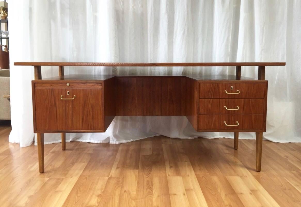 A fantastic and expansive Danish modern teak and oak floating top executive desk with drawers by Torben Strandgaard.

Teak top floats above a teak body that’s suspended between shapely oak legs, which gives what could be an imposing piece an overall