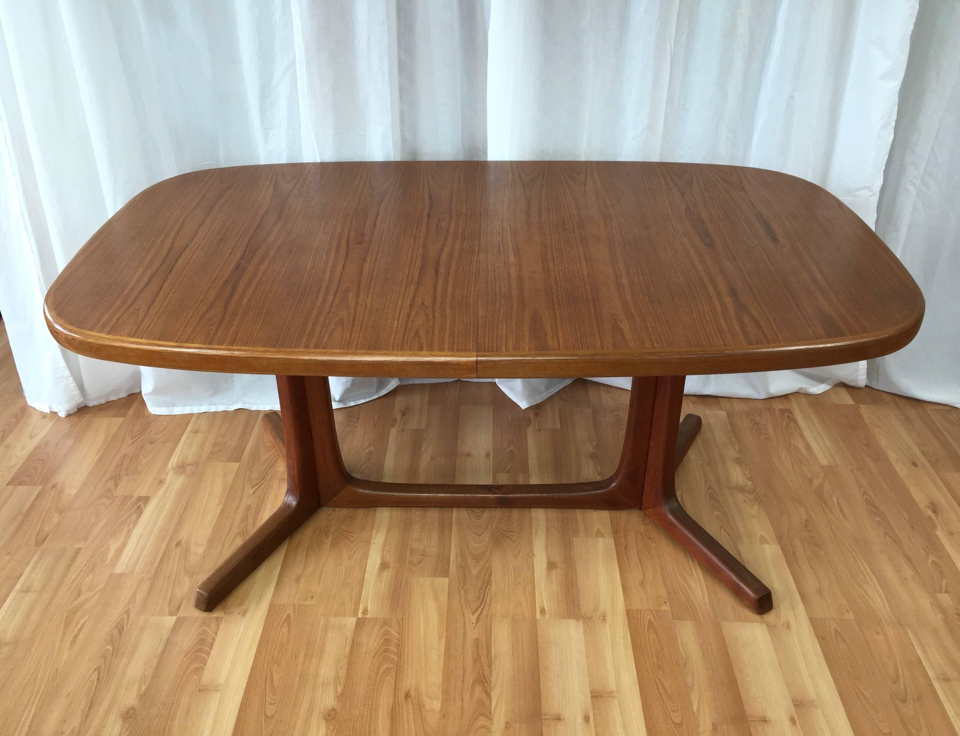 A Classic Danish modern dining table with two leaves by Niels Moller.

Substantial teak top, thick legs, and splayed feet offer a sturdy dining surface distinguished by it’s warm, lively grain. Slides apart to accommodate one or two additional