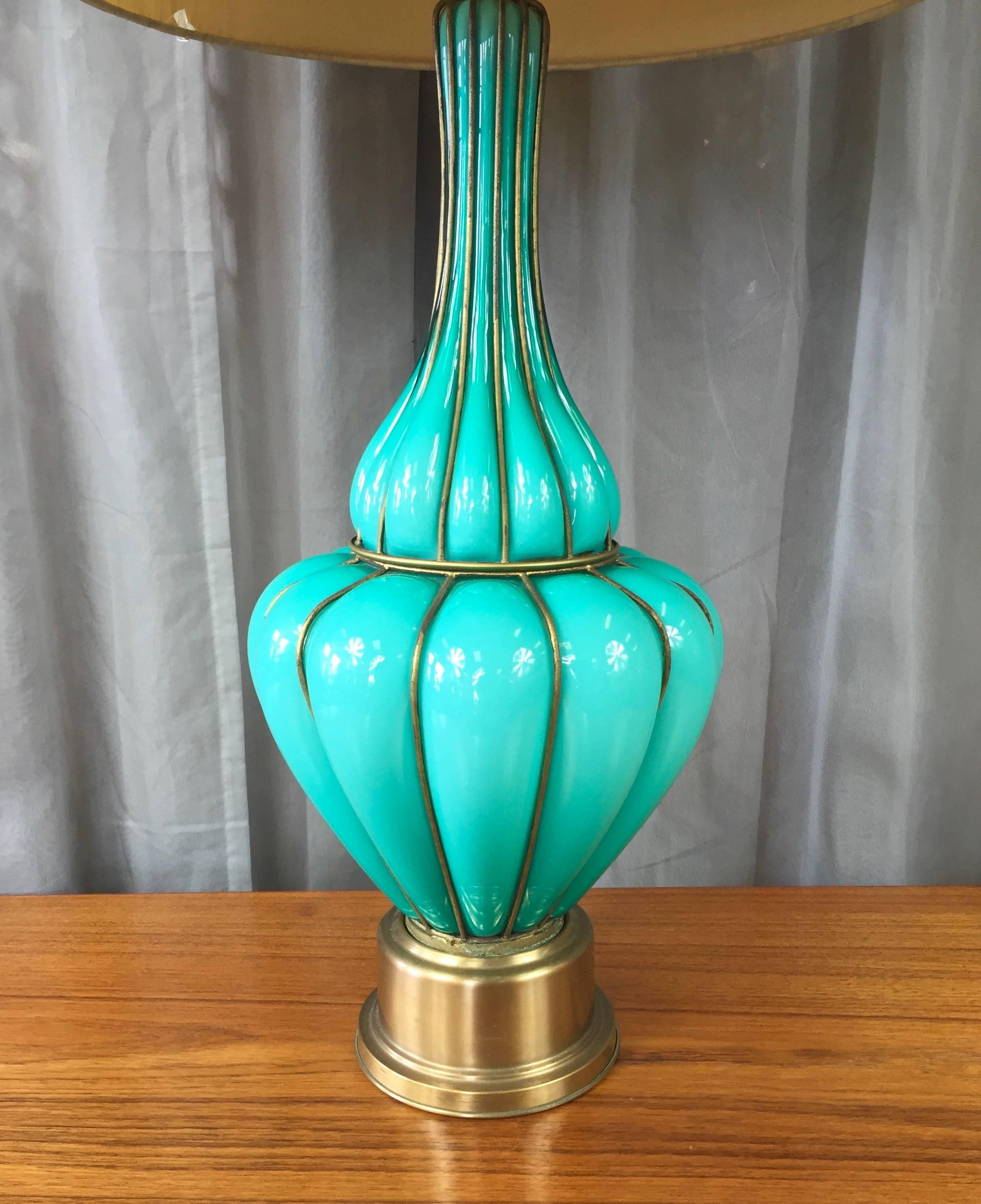 A very large and luminous Murano glass table lamp with brass base and stem and brass-colored wire cage and finial.

Opaque glass is an eye-catching and Classic Venetian shade of turquoise. Curvaceously emerges from the wire cage into which it was