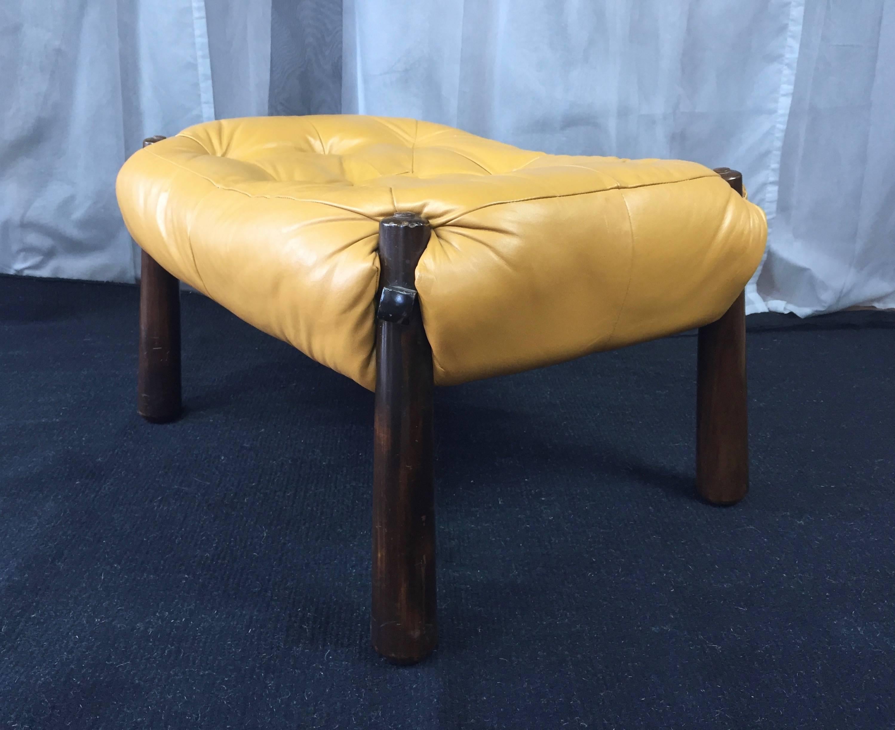 An inviting leather and Jacaranda ottoman by Percival Lafer for Lafer S.A. Ind. Com.

Comfortable over-stuffed top is upholstered in muted dijon tufted leather. Signature tapered club legs are burnt umber-stained jacaranda and feature an oversized