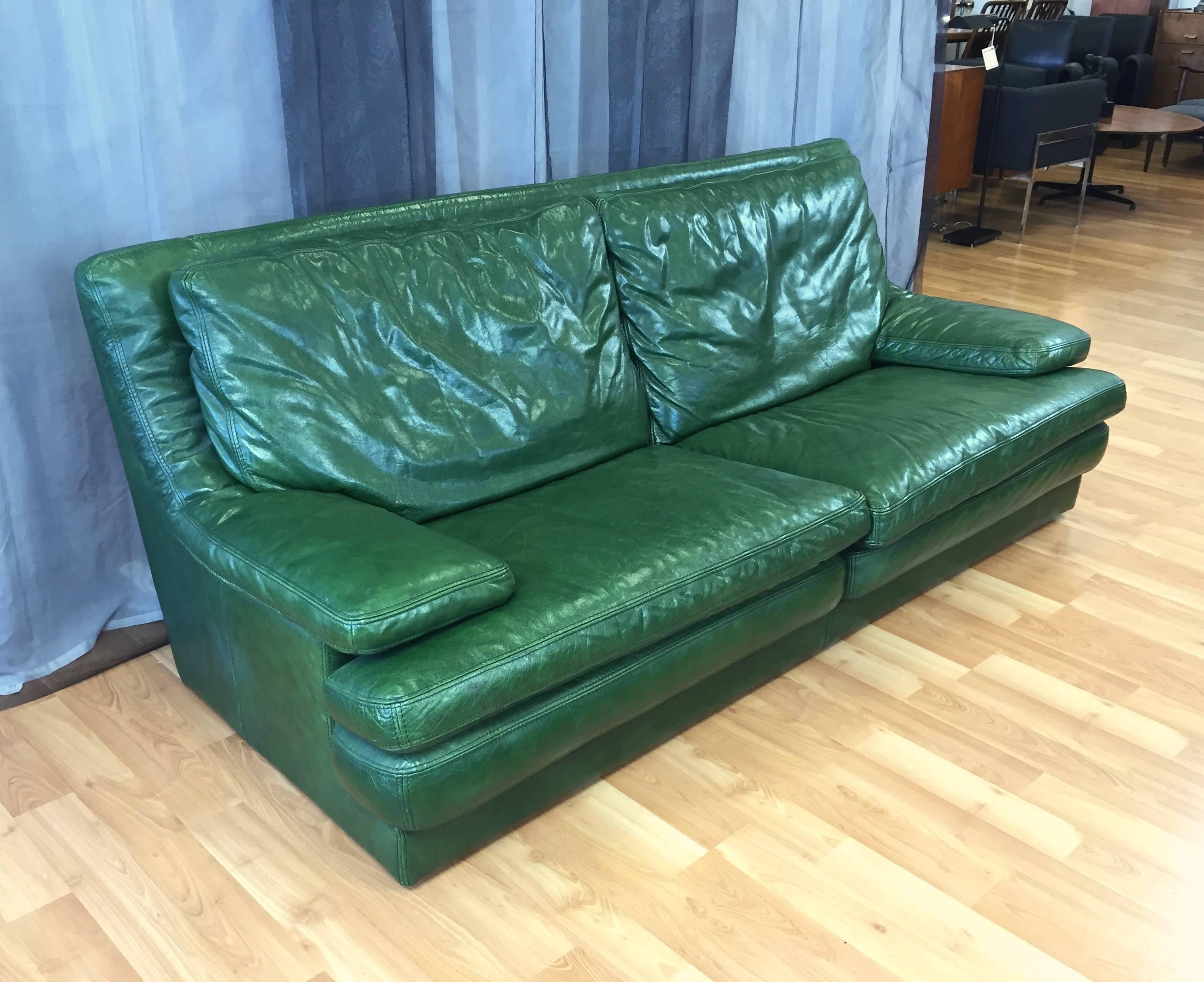 A supremely comfortable and roomy Roche Bobois vintage leather sofa and lounger in British racing green.

Both have low profile bases, seat cushions, and armrests are stacked in a casually modern design that’s very inviting. Extra-wide slab armrests