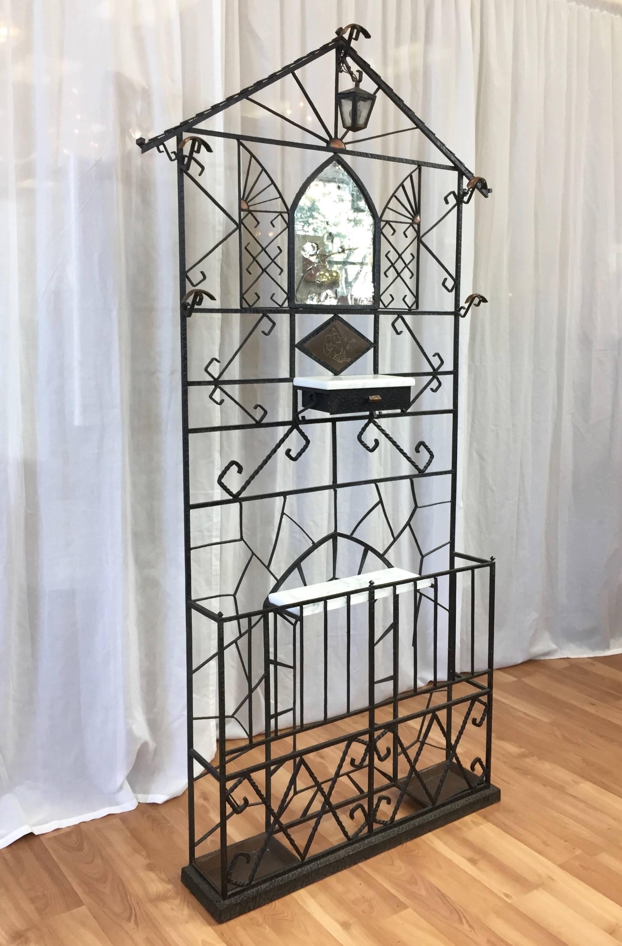 A towering French wrought iron hall tree or stand with copper, marble, and mirror elements.

Greet your guests in style with this gothic-infused Art Deco show stopper. Textured black wrought iron frame has shingle detailing on top, from which