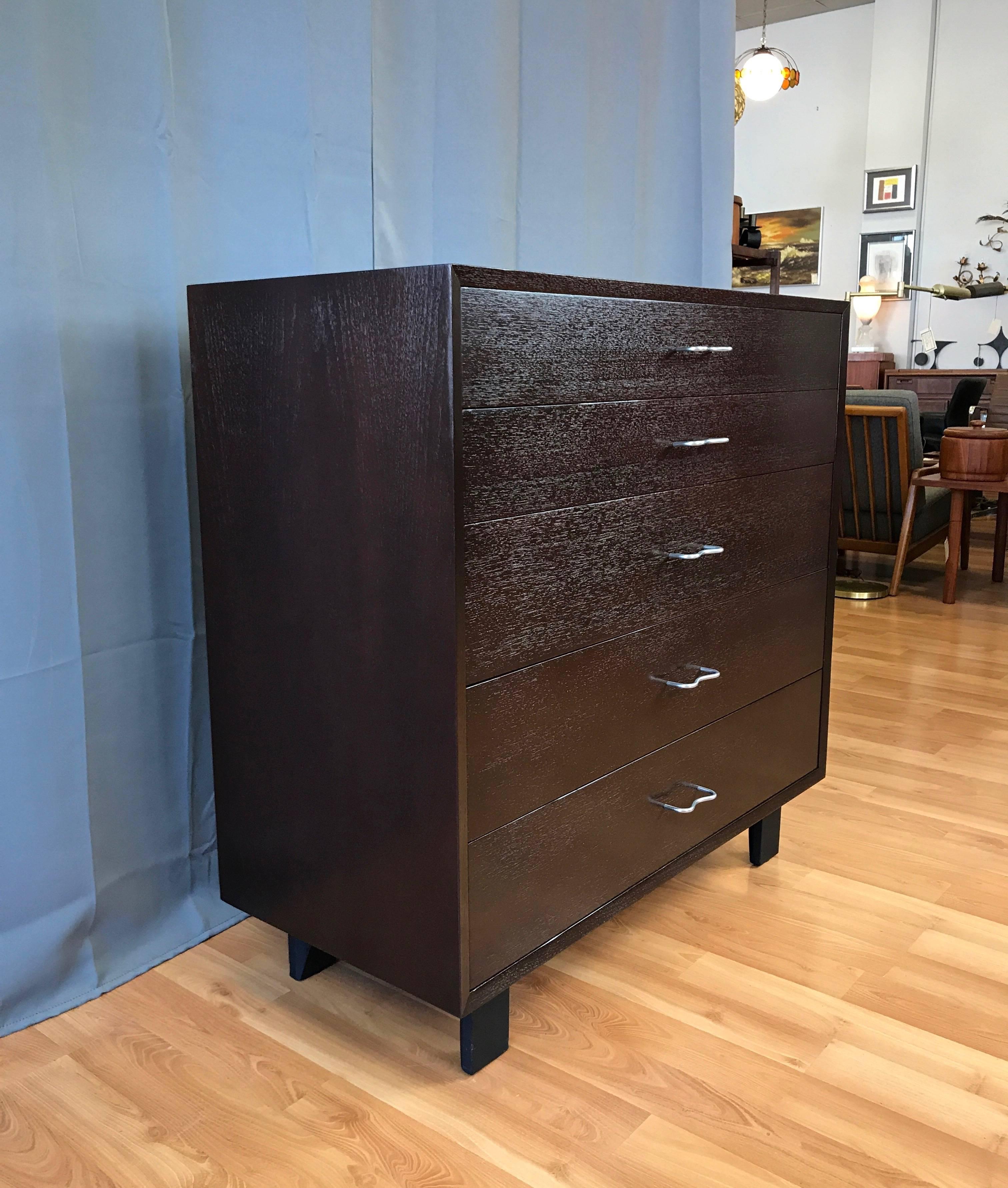 A Mid-Century Modern five-drawer walnut dresser or chest by George Nelson from his “Basic Cabinet Series” for Herman Miller.

Exceptional semi-gloss dark raw umber finish subtly showcases figured grain while retaining a hint of wood texture. Top