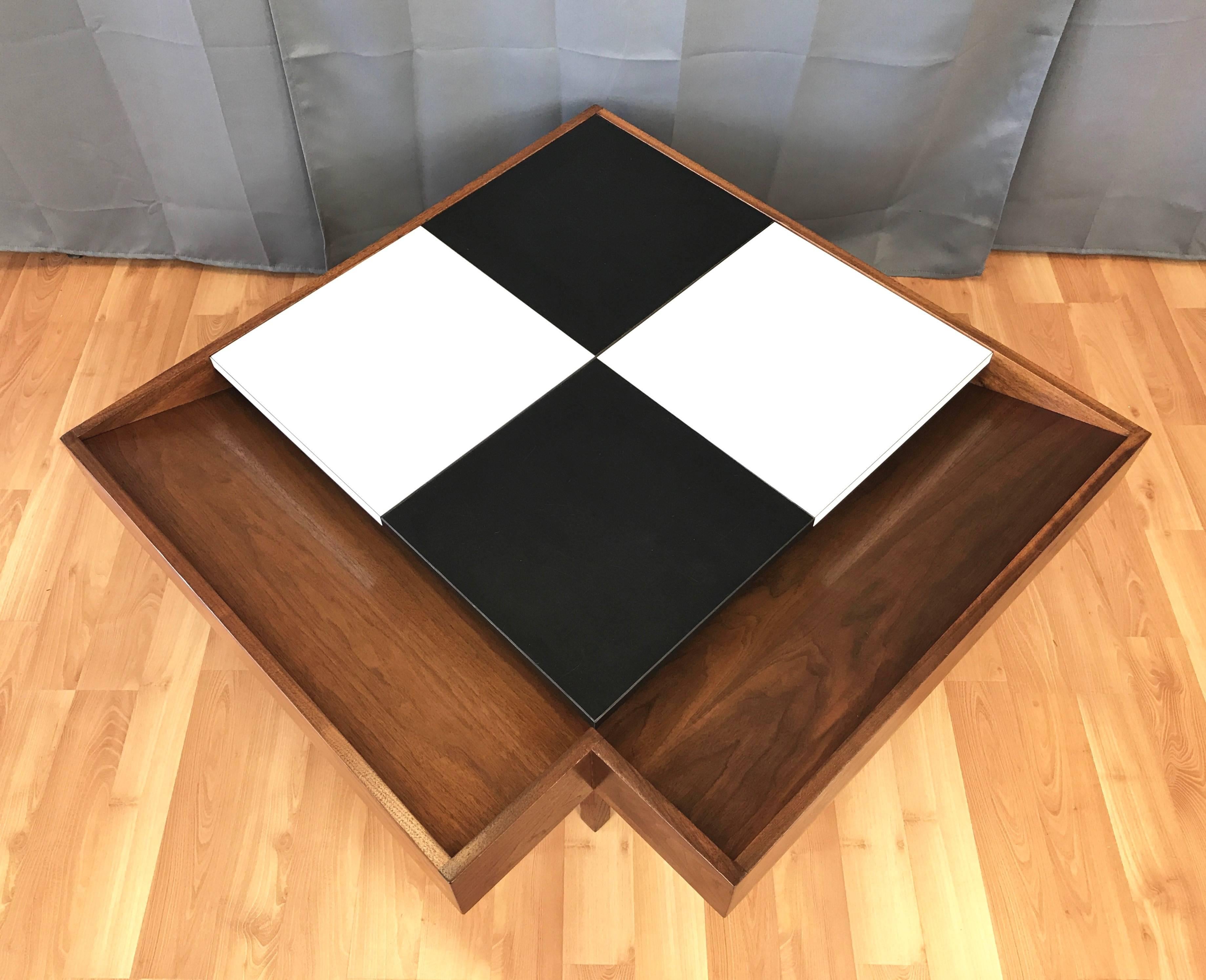 A fantastic Mid-Century Modern walnut coffee table with checkered laminate top by John Keal for Brown-Saltman.

Spacious table has a pair of overhanging bins with angled interiors for the display of magazines and books. Eye-catching original black