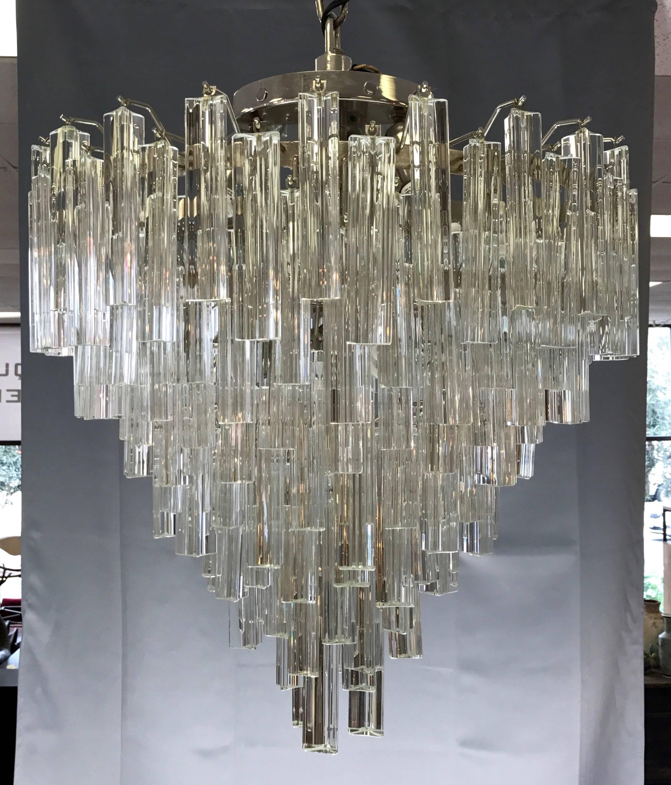 A large and spectacular “Prismi” Murano glass seven-tier chandelier by Venini.

Dazzling cascade of hundreds of 6”-long solid glass trihedral prisms hang from staggered metal spokes that emanate from a polished nickel cage with seven stepped tiers.