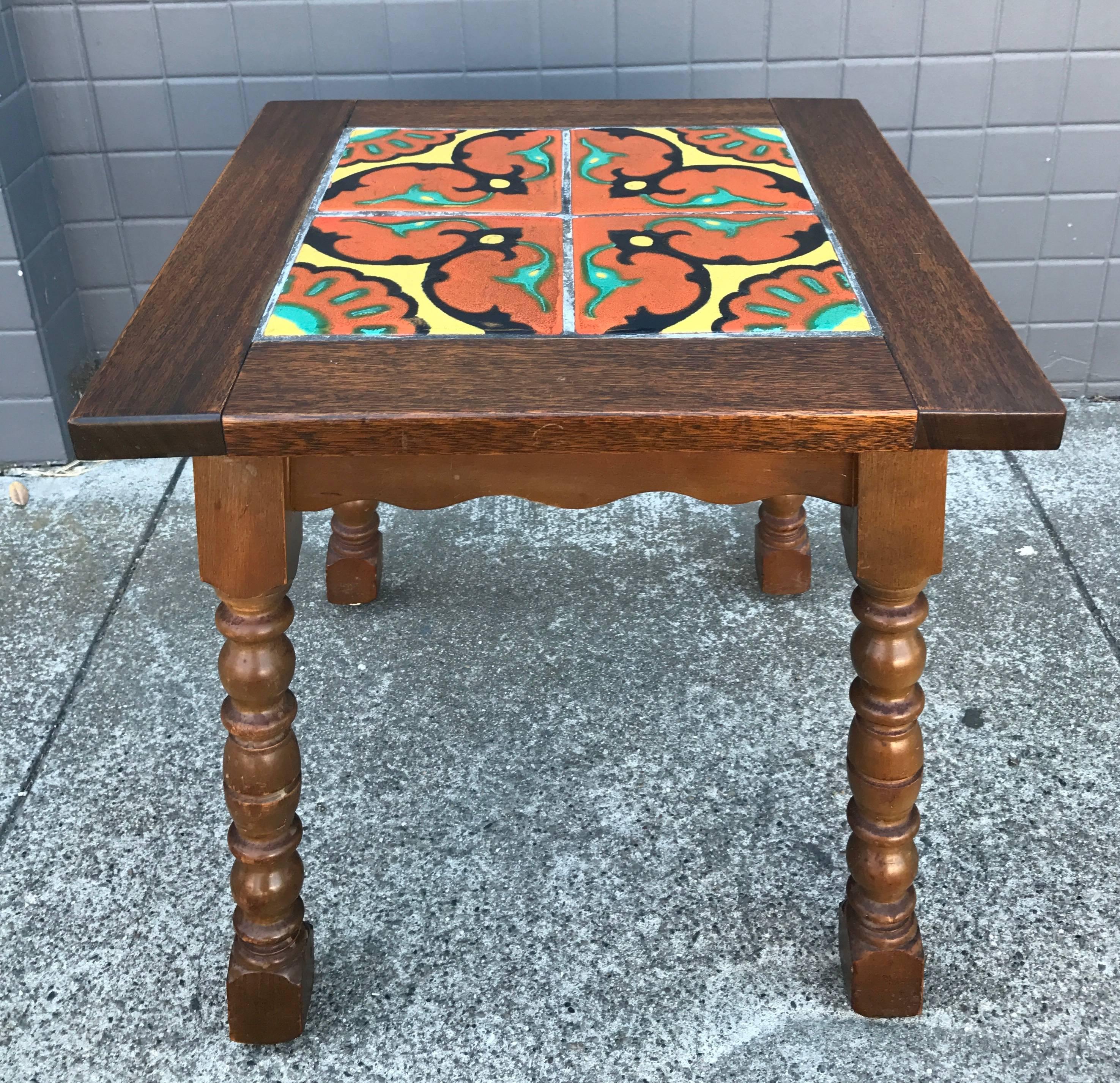 A delightful small mahogany side or occasional table with Spanish-influenced tile top by California designer and artist Taylor Tilery.

Festive four tile design features five glossy glaze colors, unlike his Moorish designs which only used three.