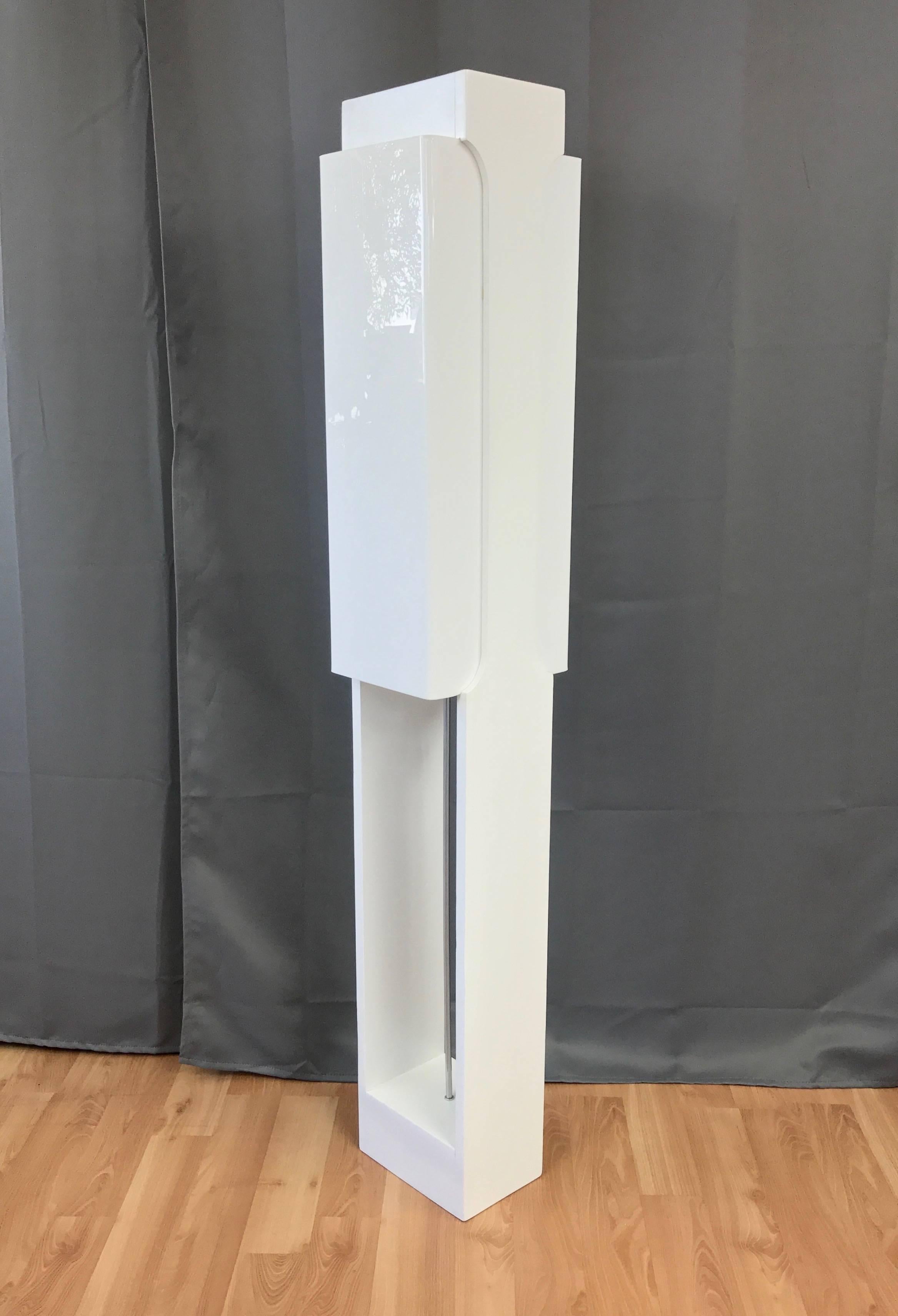 A, circa 1970s streamlined and architectural lacquered wood and acrylic floor lamp.

Clean lines and bright white satin finish result in a Minimalist design that’s equal parts mod and futuristic. Wood body with open bottom half has a nice cut-out