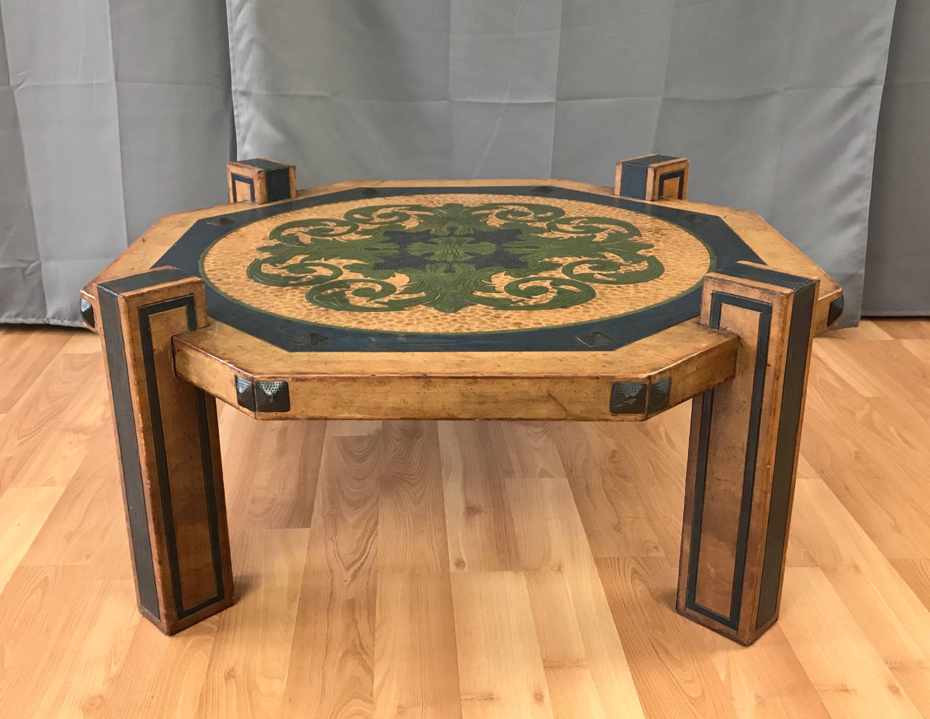 An impressive, circa 1970s Arts & Crafts-style leather clad octagonal coffee table done in the manner of Maitland-Smith.

Fully finished in exactingly applied hand-tooled, colored, and antiqued leather. Regally executed medallion depicting