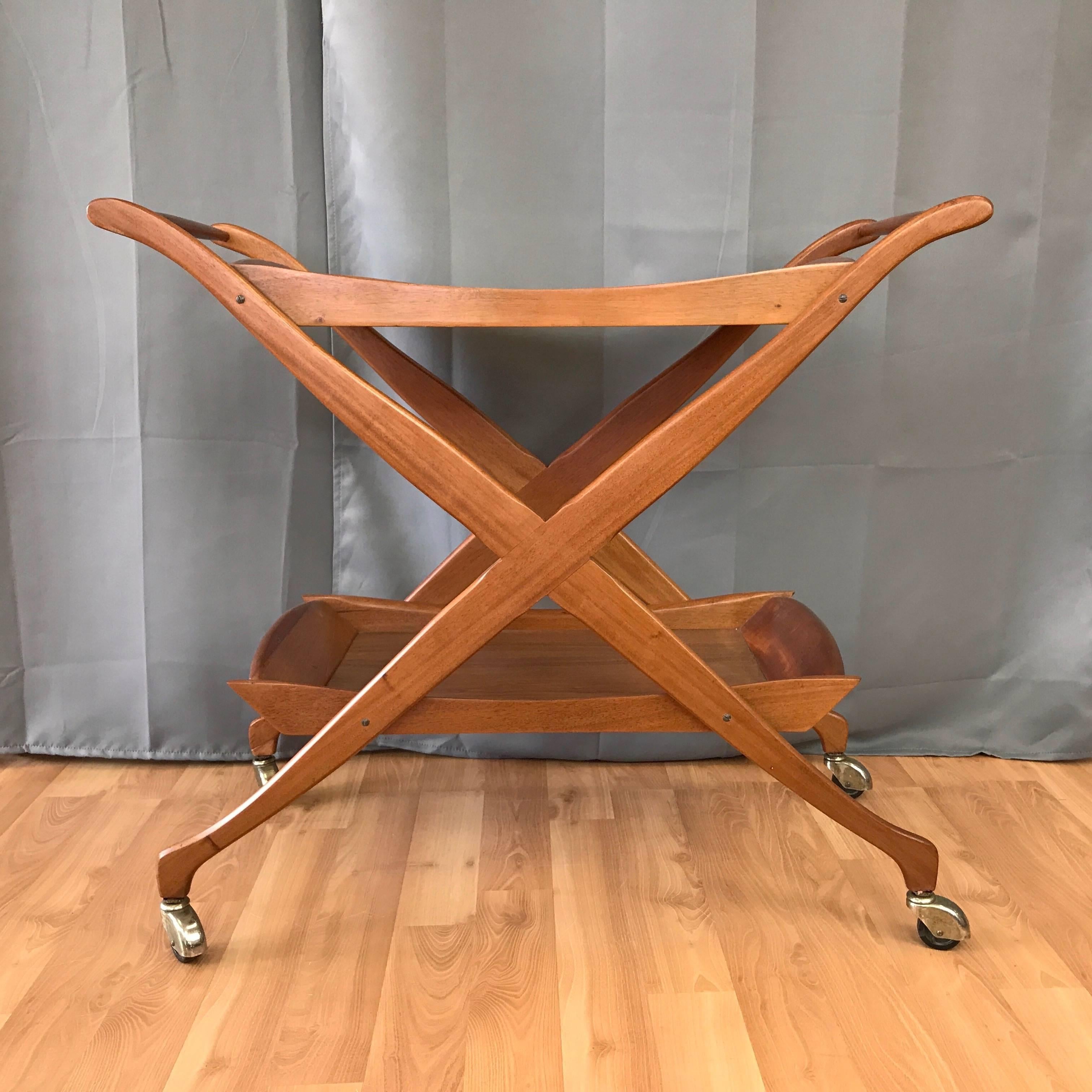 A vintage walnut serving, bar, or tea cart with two tiers and X-shaped legs.

Scissor-style solid walnut sides have very graceful lines that are echoed by the solid walnut frames of each tray-like tier. Solid walnut tapered dowel handles. Serving