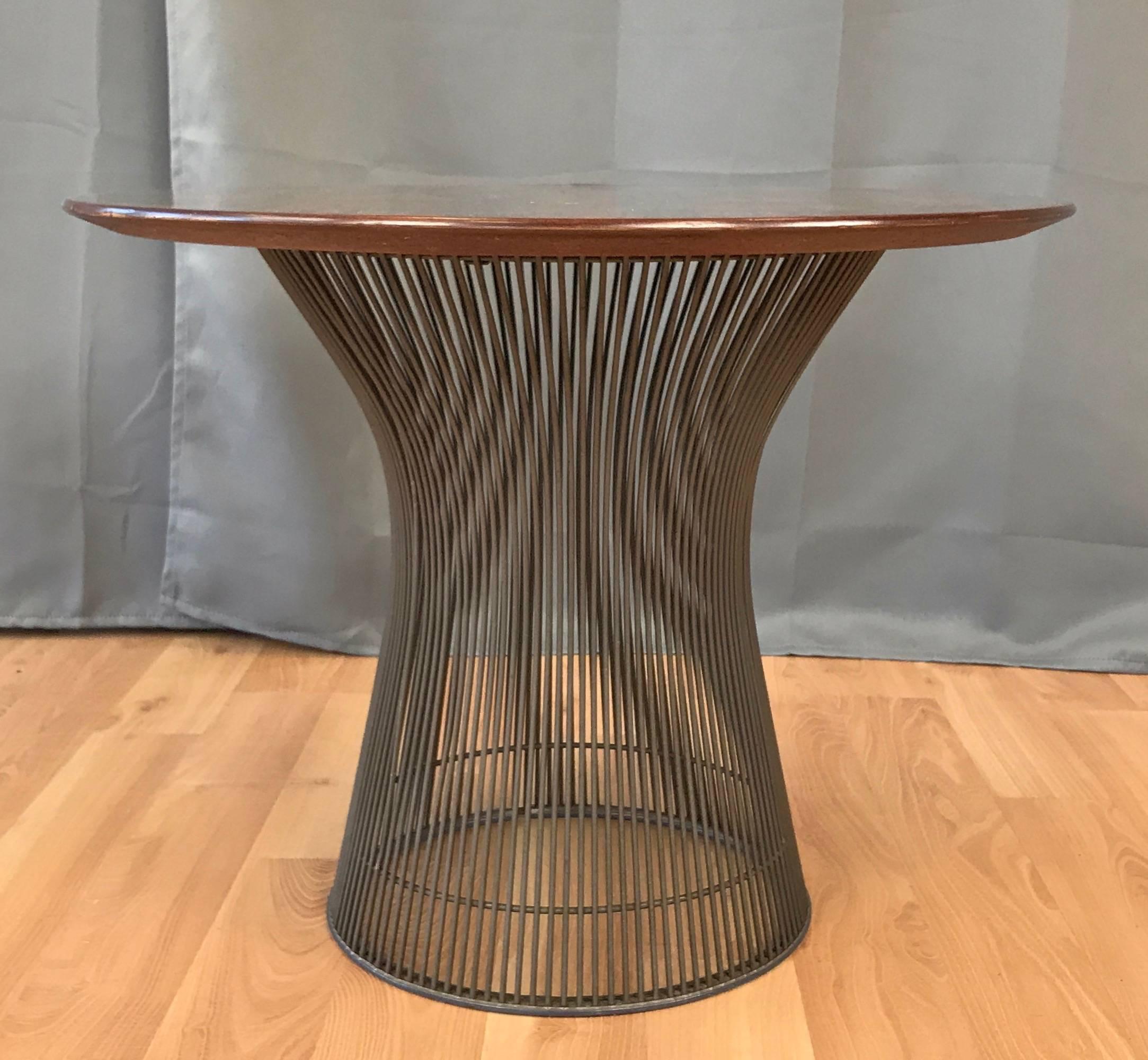 A vintage rosewood and bronze side or occasional table designed by Warren Platner for Knoll International.

Stunning bookmatched rosewood veneer top has an eye-catching depth and complexity to its lively grain pattern. Bronze wire base has