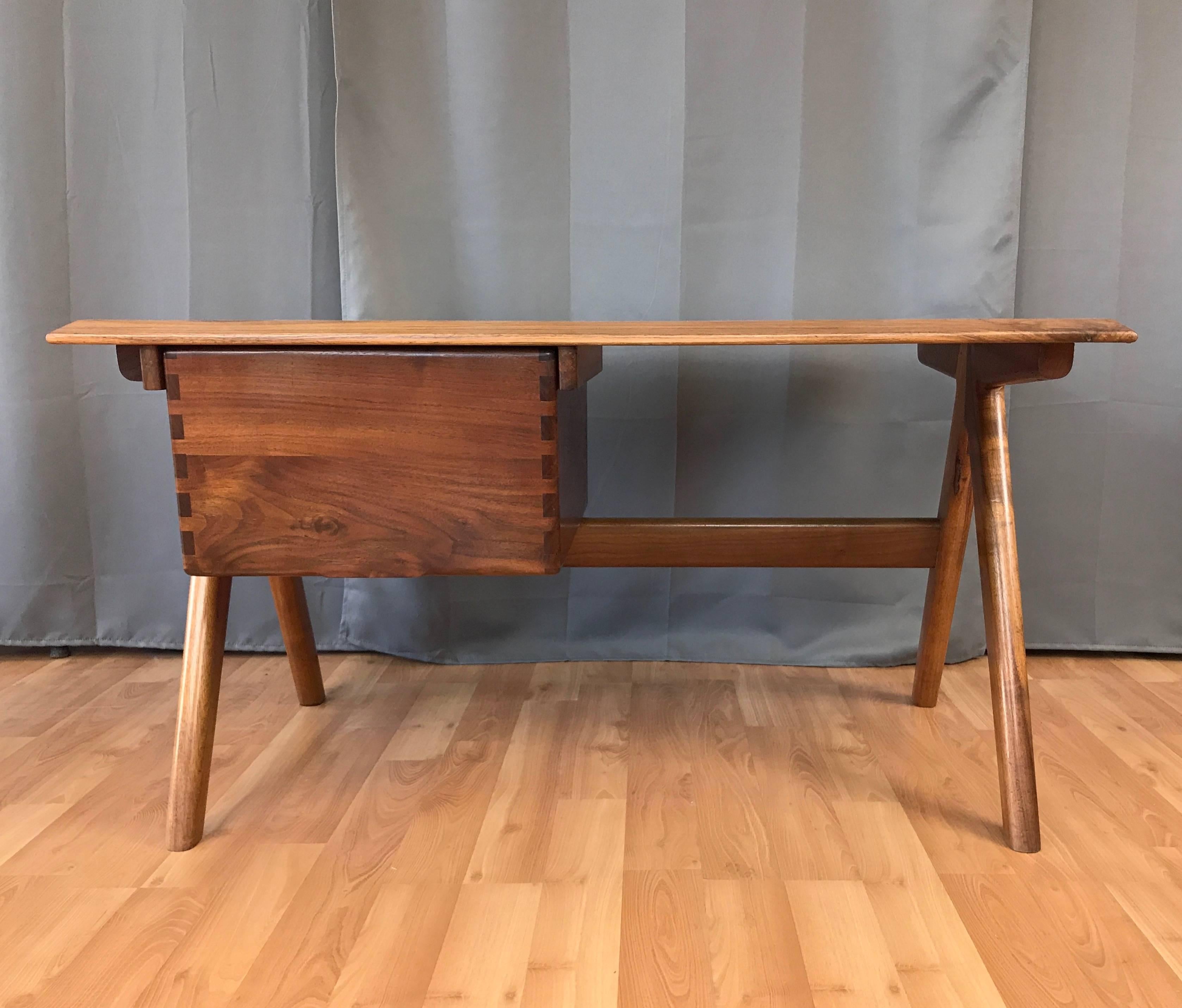 A substantial solid rosewood and padauk desk with drawer by Berkeley, California, master woodworker Jim Sweeny.

Impressive craftsmanship and construction throughout. Expansive rosewood top has a broad knife edge. Suspended padauk drawer boasts