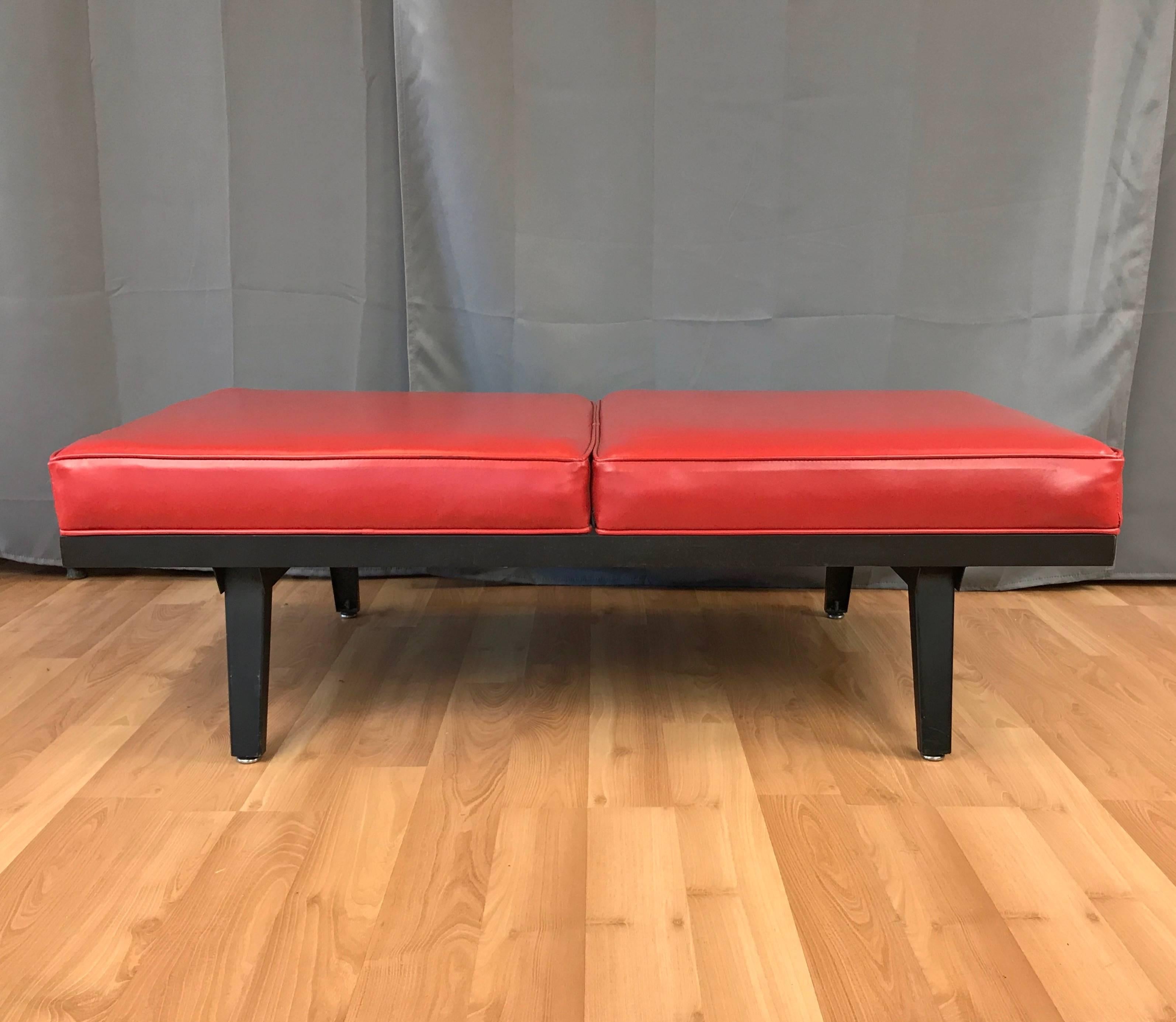 A vintage two-seat bench by George Nelson from his Steelframe series for Herman Miller.

Generously-sized cushions upholstered in original bright red vinyl. Steel and wood base and legs finished in matte black. A traffic-stopping example of