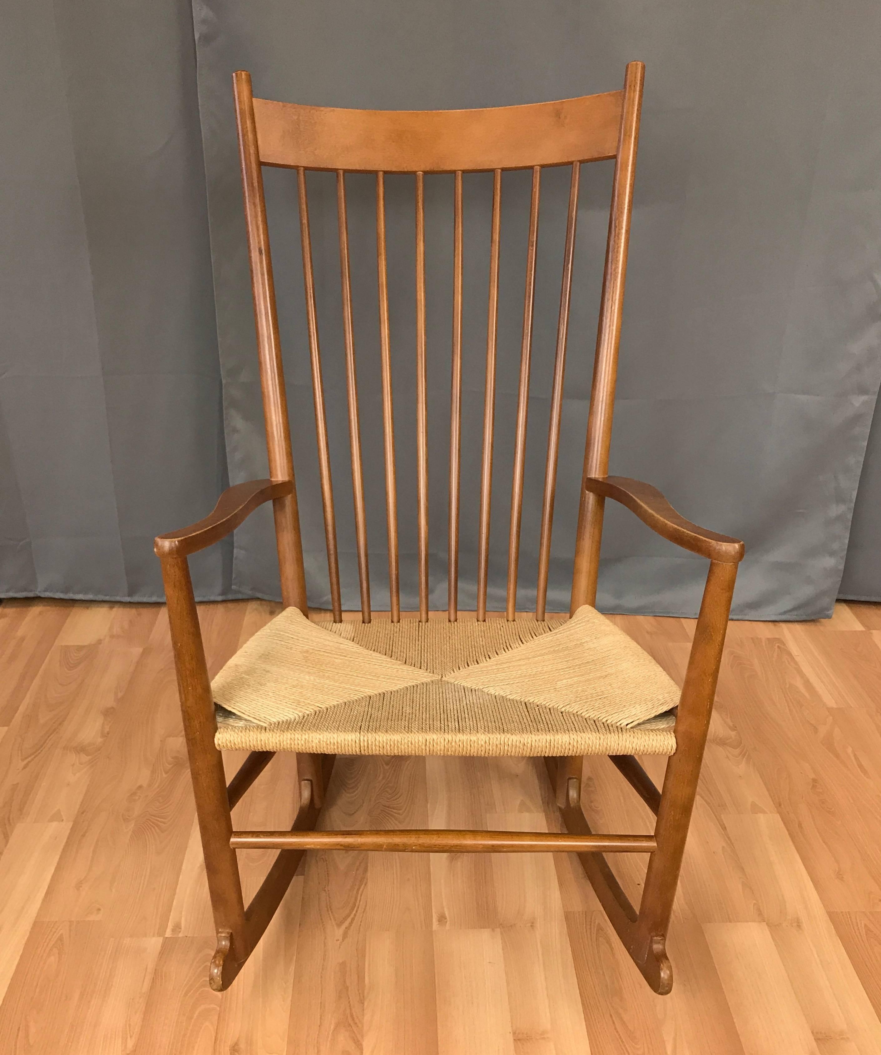 A vintage J16 rocking chair by Hans Wegner in honey-colored beech with woven papercord seat.

Designed in 1944 and initially produced by FDB Møbler, this example dates from 1984 and was manufactured by Fredericia Furniture. Displays Wegner’s