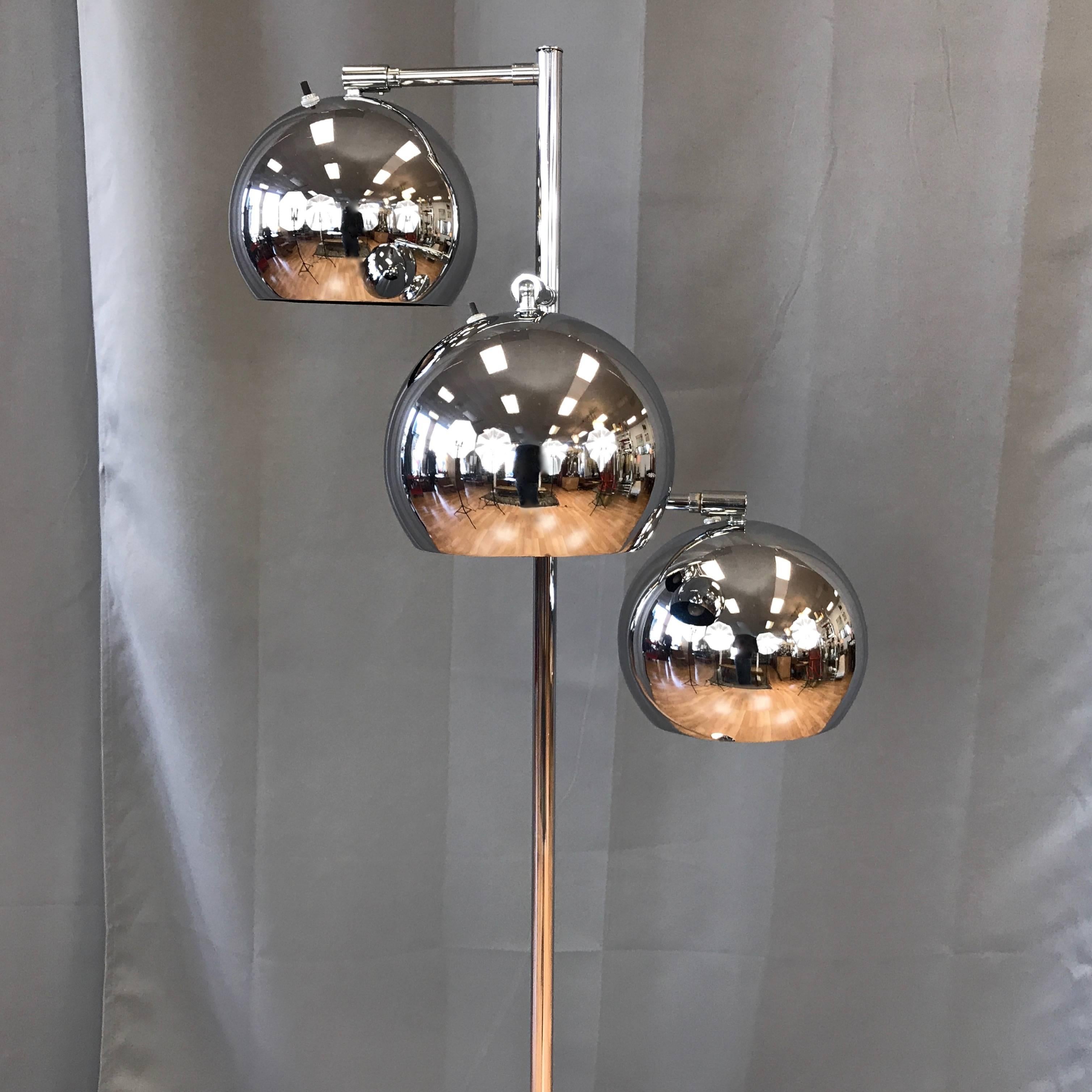 A fantastic vintage chrome floor lamp with a trio of articulated eyeball-style orb lights by OMI for Koch & Lowy. 

Gleaming globe shades with matte black interiors rotate and swivel on fixed arms, allowing for precise positioning. They’re