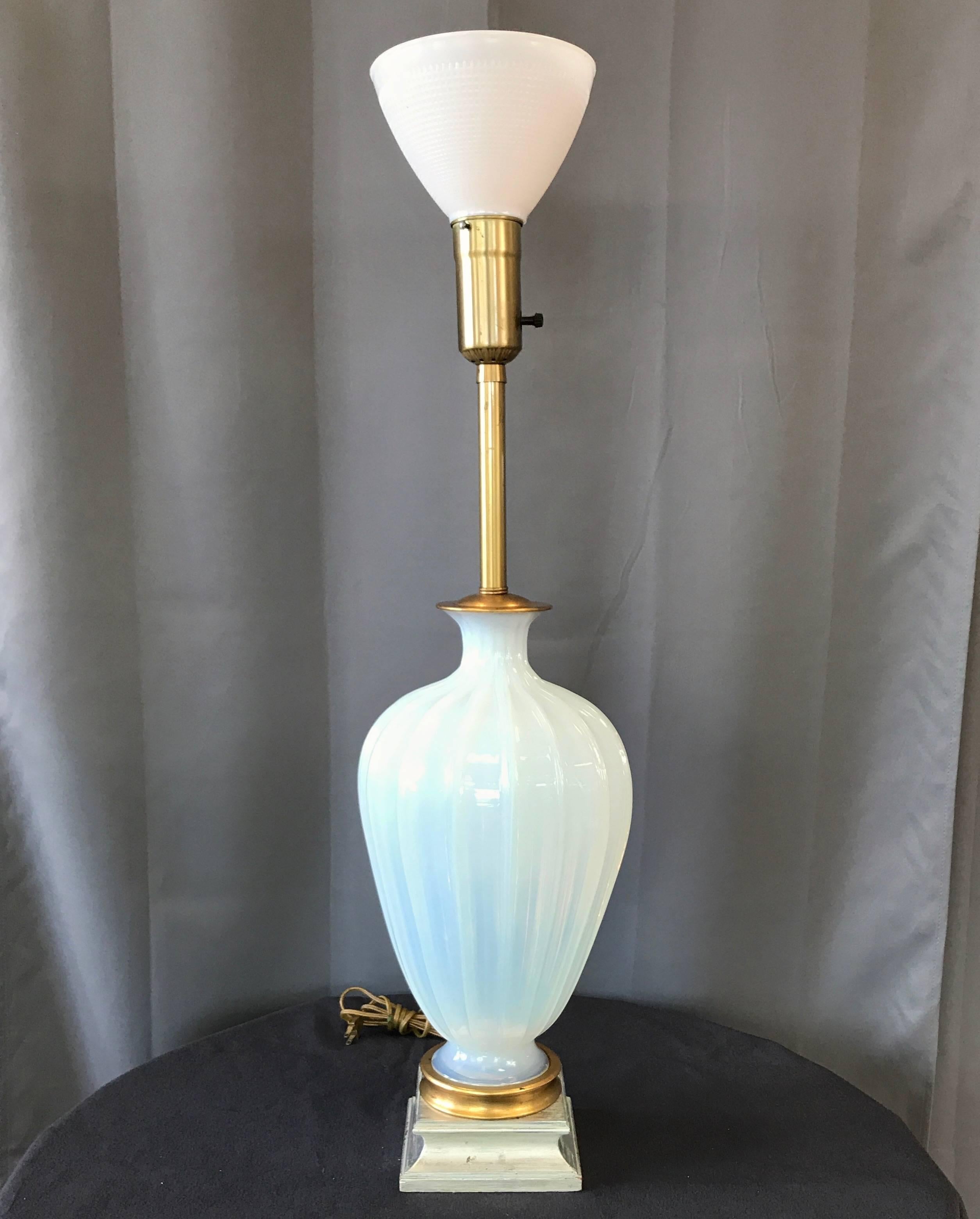 A statuesque Murano glass opaline table lamp with gold and silver accents by Seguso for Marbro Lamp Company.

Elegant and ethereal handblown ribbed body in semi-opaque and milky sky blue glass. Top and bottom caps finished in gold leaf.