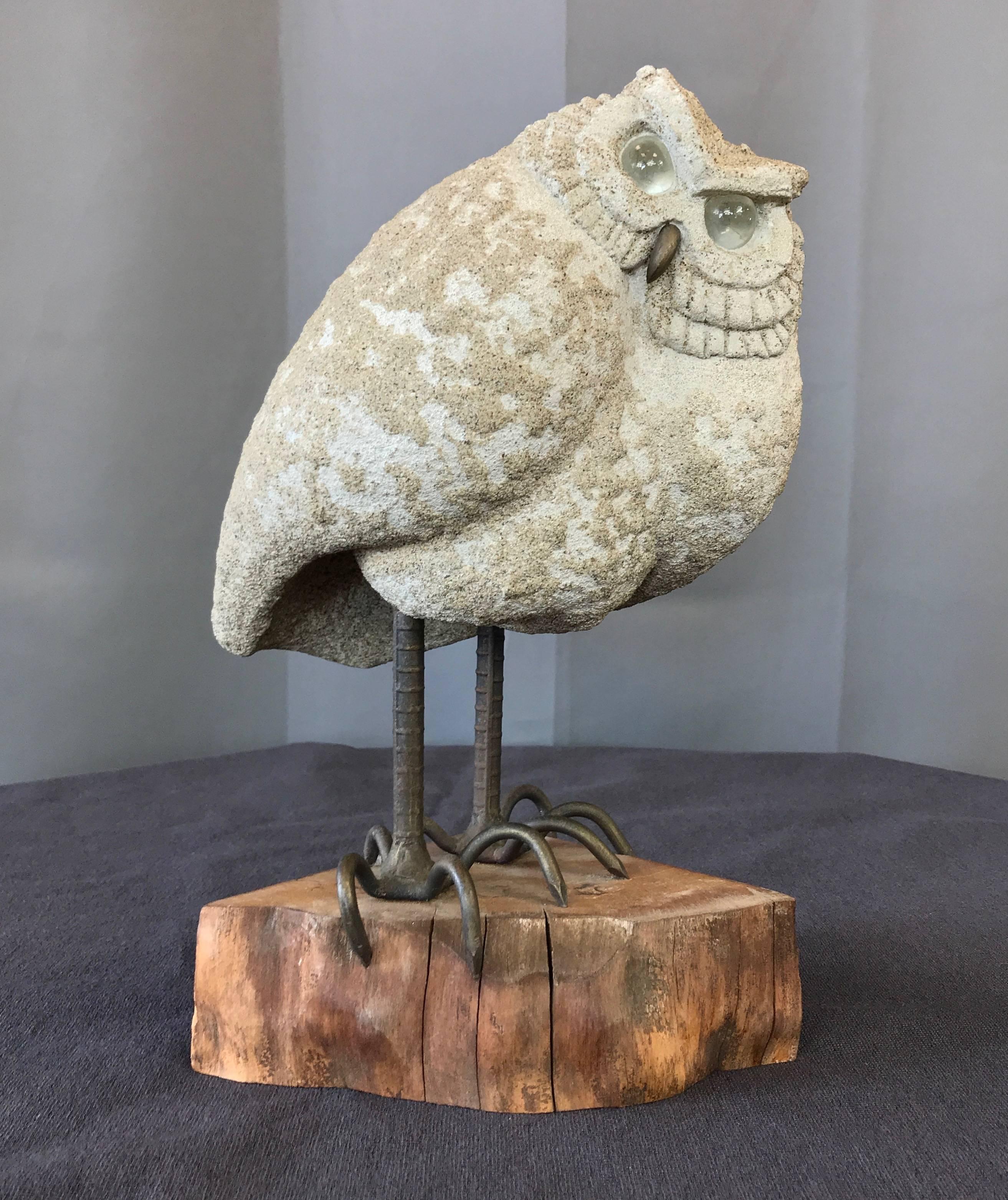 An elusive and endearingly judgmental owl sculpture by celebrated midcentury California artist Lou Rankin.

Stand-offish sandy-textured cast concrete body, with large clear glass eyes that direct an incredulous gaze. Bronze-finish metal beak, with