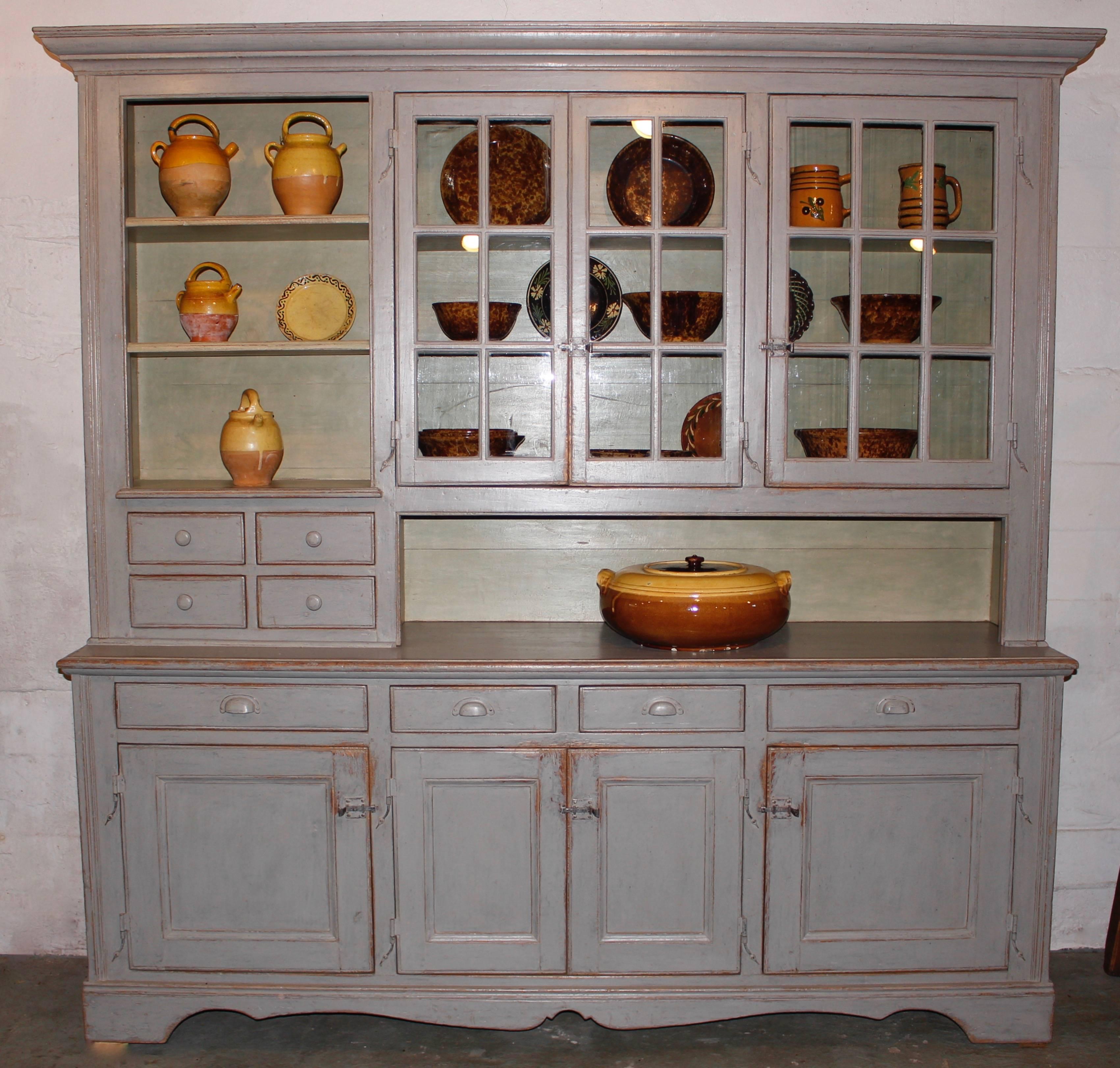 A setback cupboard found in Quebec. It has plenty of storage with doors and drawers and open shelving to display pottery, dishes or art work.