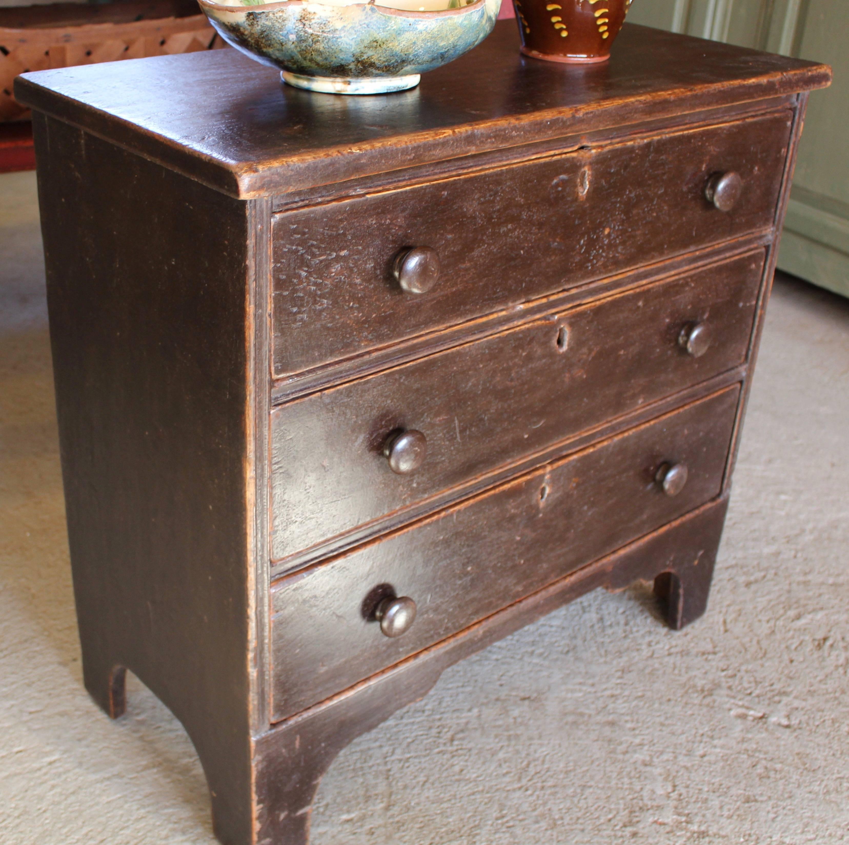 A brown petite chest of three drawers