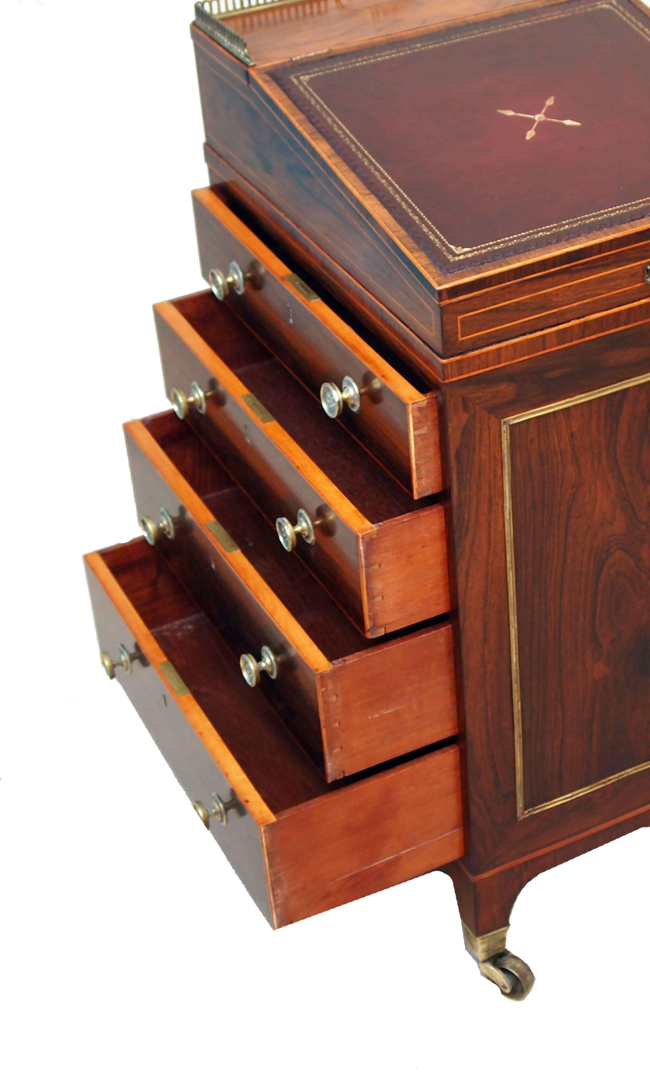 An exceptional quality Regency period rosewood Davenport with original brass gallery incorporating carrying handle to gilt tooled leather inset turning top above four drawers opposed by four false drawers and slide raised on square tapering feet