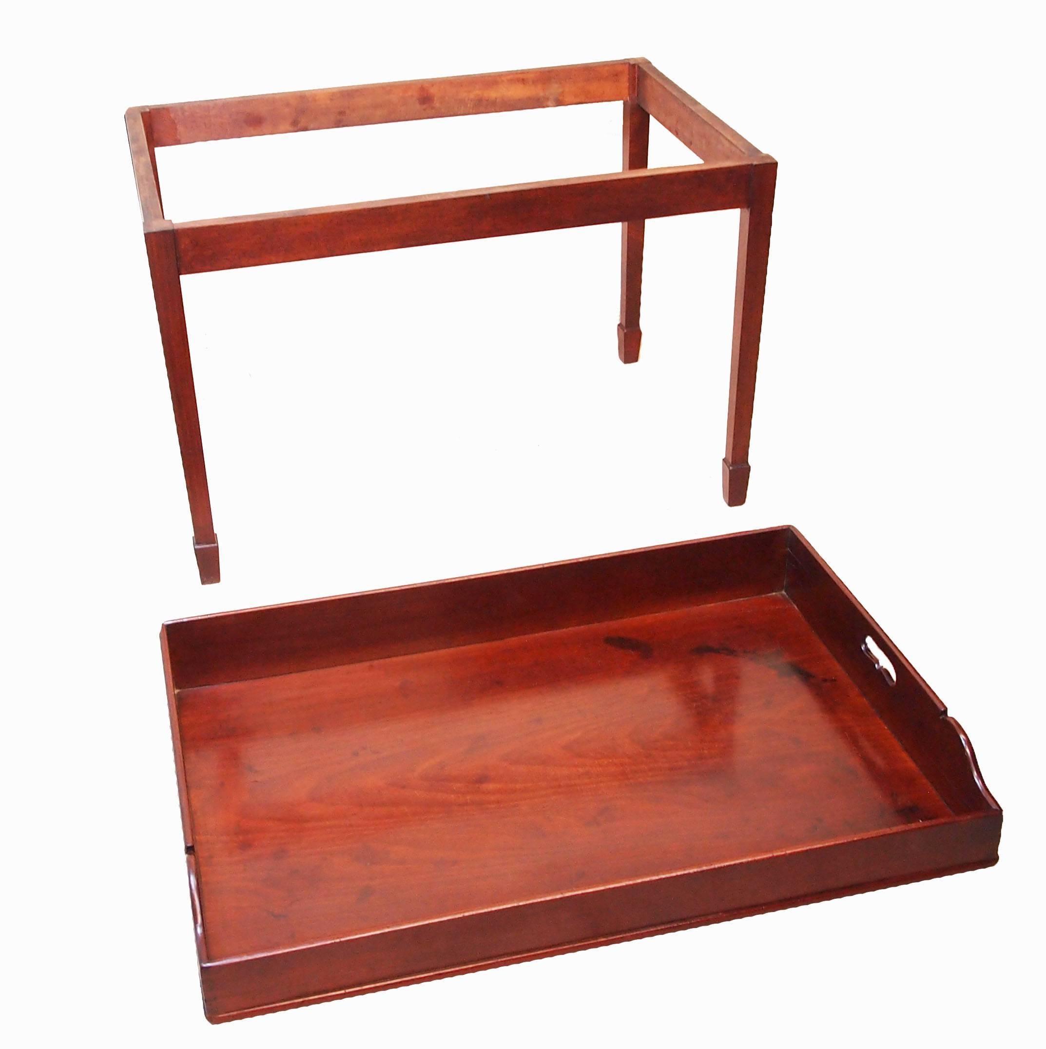 A good quality George III mahogany butlers tray having pierced handles to well
figured gallery top housed on later square tapering leg mahogany stand.