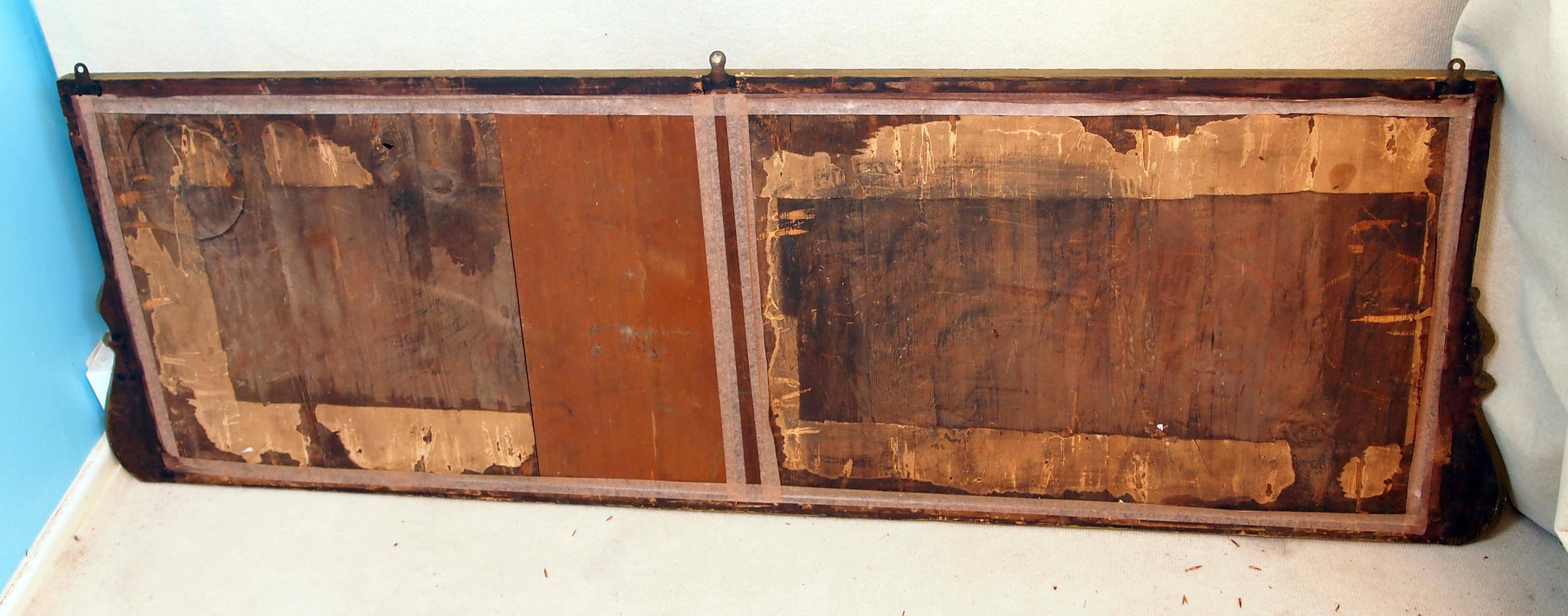An extremely rare early 18th century Georgian overmantle mirror of good proportion having replaced triple section plate surrounded by carved frame and scrolling wings.

            